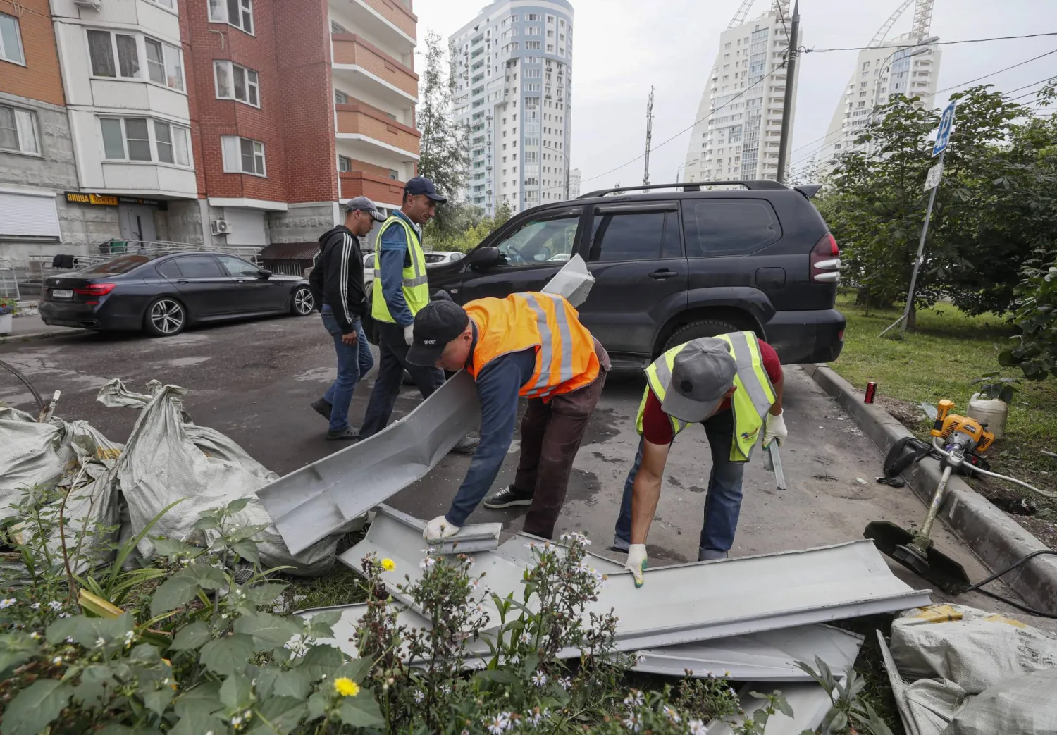 أرشيفية لعمال ينظفون موقع إسقاط طائرتين بدون طيار في محيط موسكو (إ.ب.أ)
