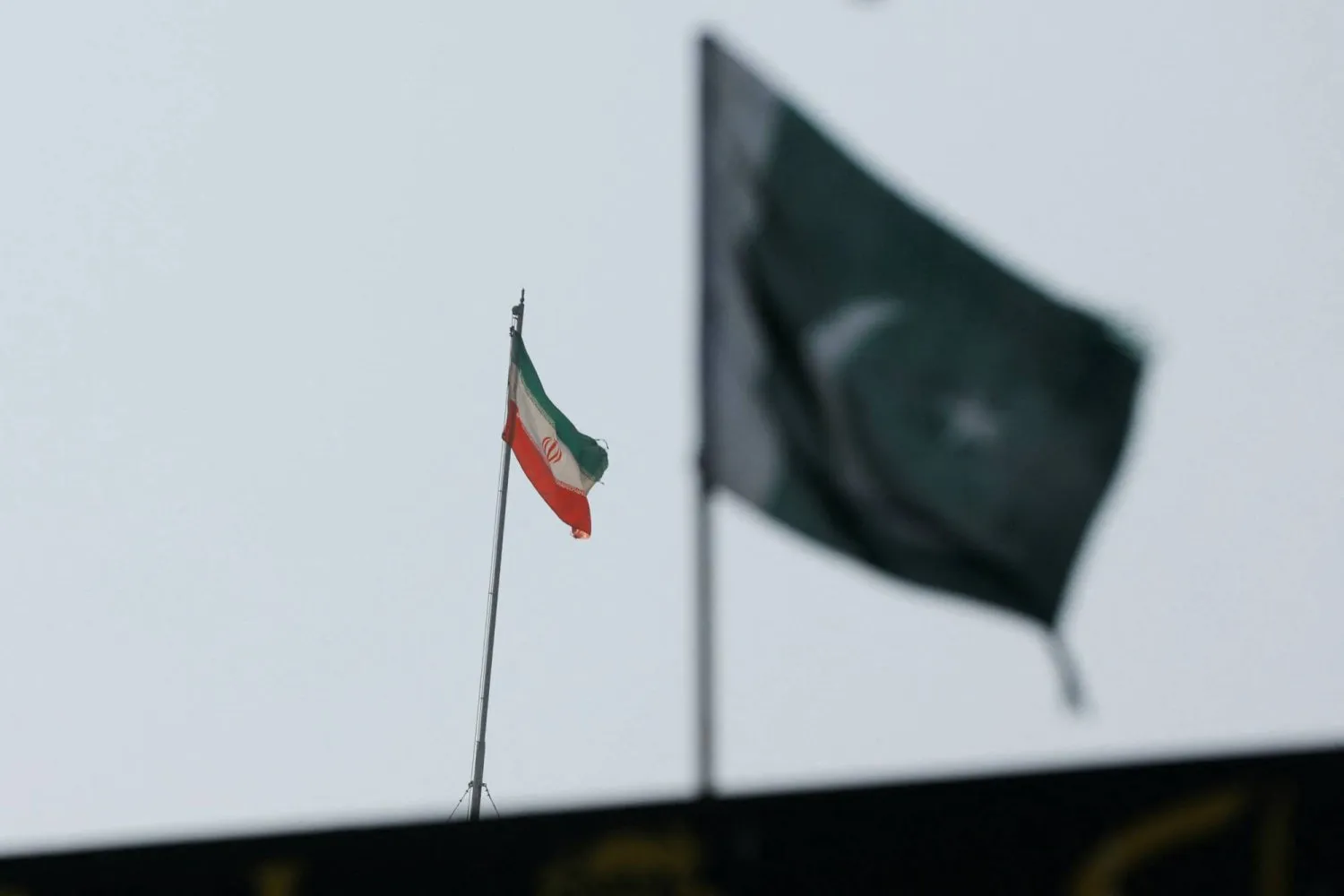 Konsolosluk binasının üzerinde İran bayrağı görünüyor, arka planda da Pakistan bayrağı var (Reuters)