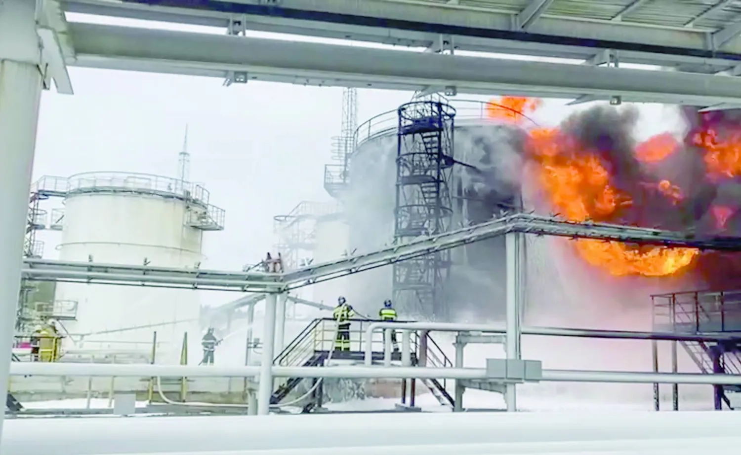 إطفائيون روس يحاولون السيطرة على حريق بمستودع نفطي غرب البلاد عقب هجوم بمسيّرة أوكرانية يوم الجمعة (إ.ب.أ)