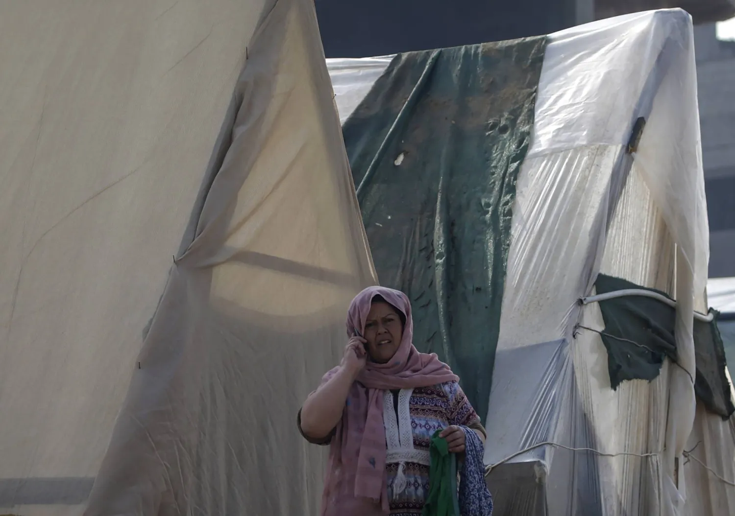 سيدة فلسطينية تجري مكالمة هاتفية في مخيم للنازحين بدير البلح في 9 يناير (كانون الثاني) (إ.ب.أ)