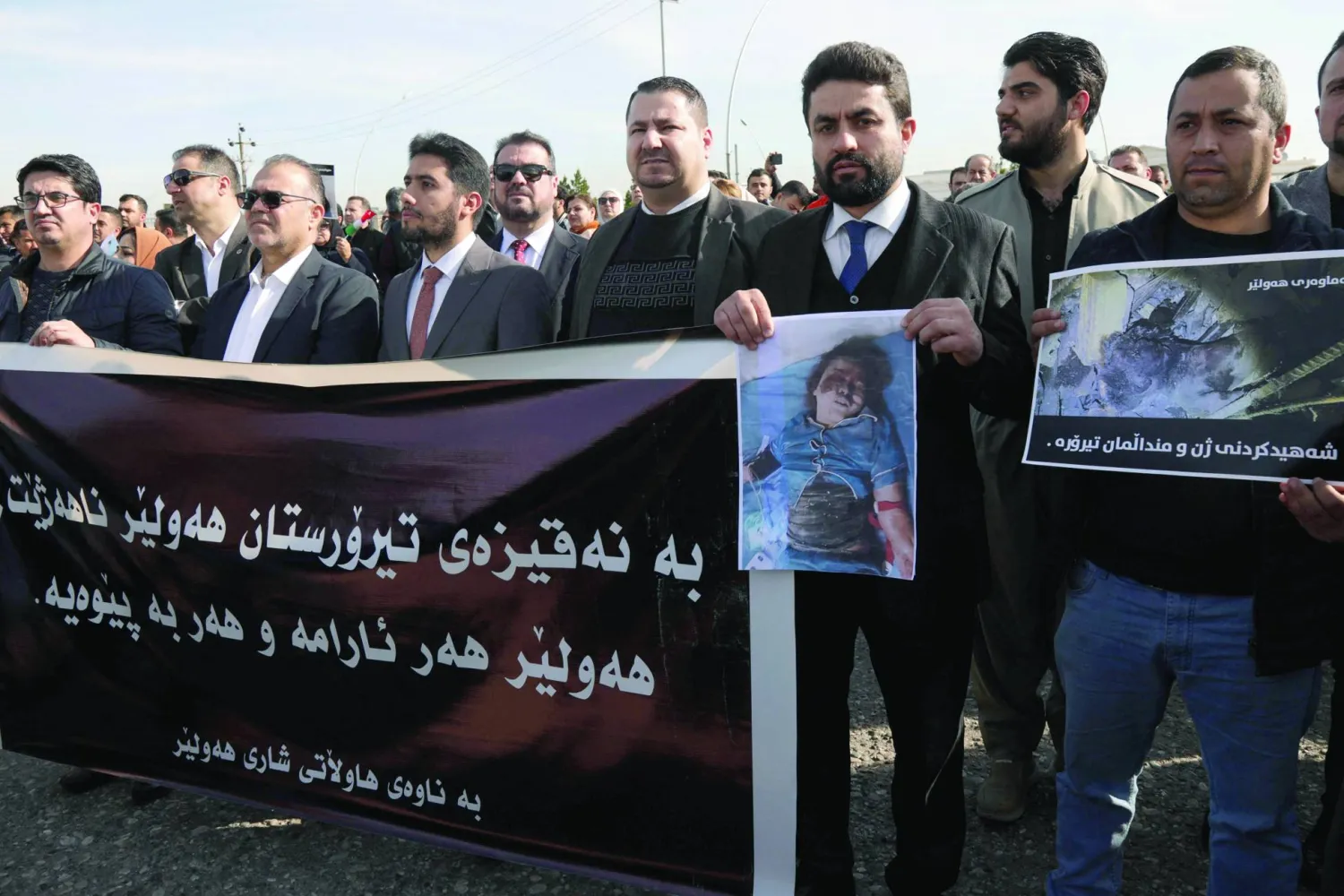 متظاهرون يحملون لافتة بالكردية كُتب عليها «الإرهاب لن يهز أربيل... المدينة ستبقى قوية ومستقرة» (أ.ف.ب)