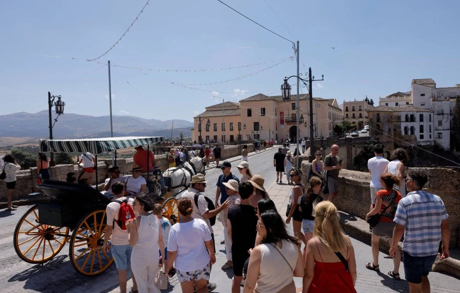 FILE PHOTO: Tourists tour along the Puente Nuevo (New Bridge) on a hot summer day in Ronda, Spain July 4, 2023. REUTERS/Jon Nazca/File Photo