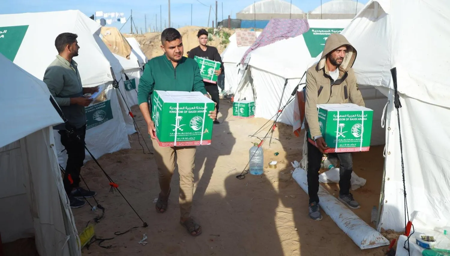 فلسطينيون يتسلمون المساعدات السعودية (واس)