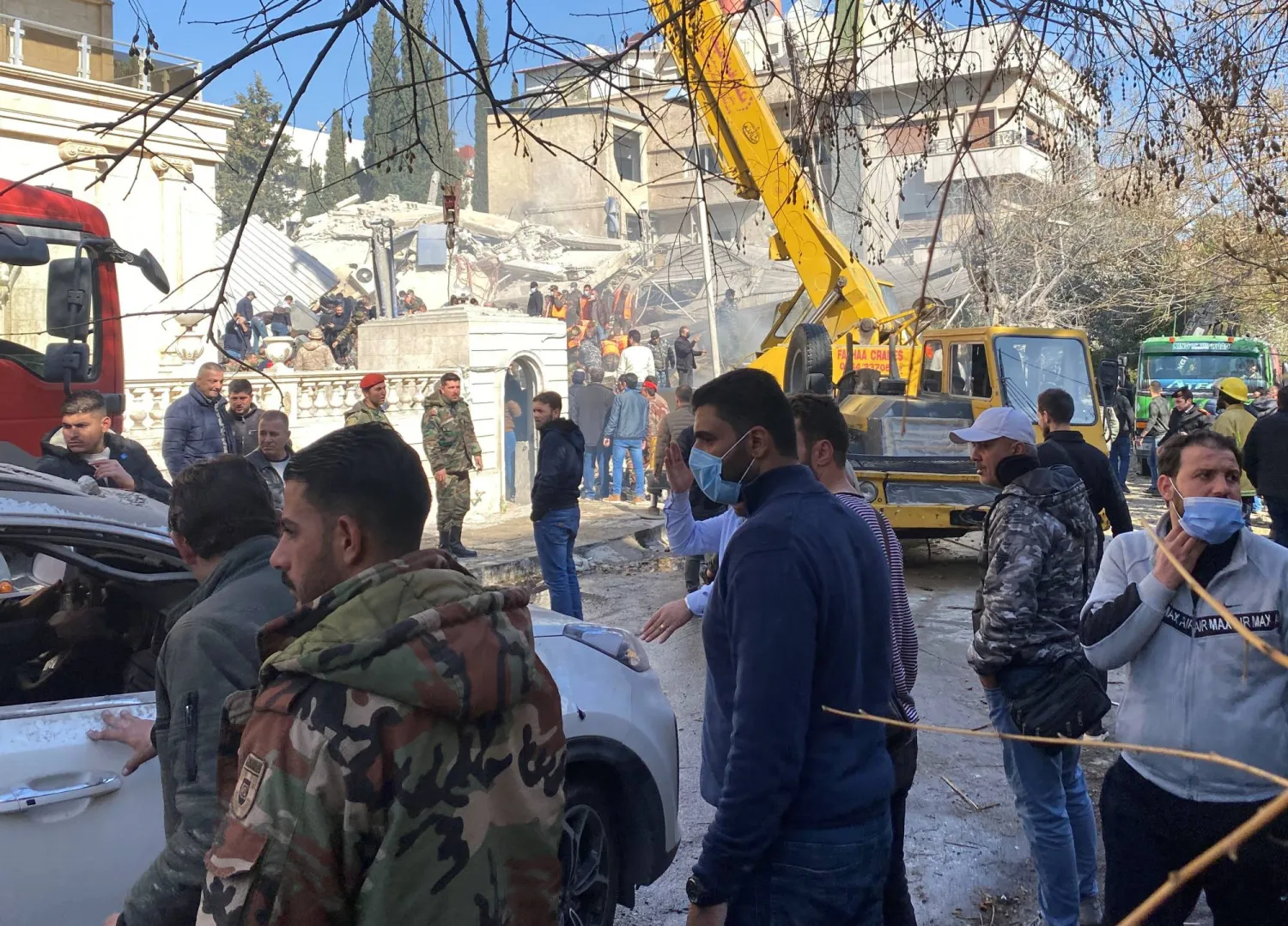 أفراد من قوات الأمن السورية أمام مبنى قصفته إسرائيل في دمشق (رويترز)