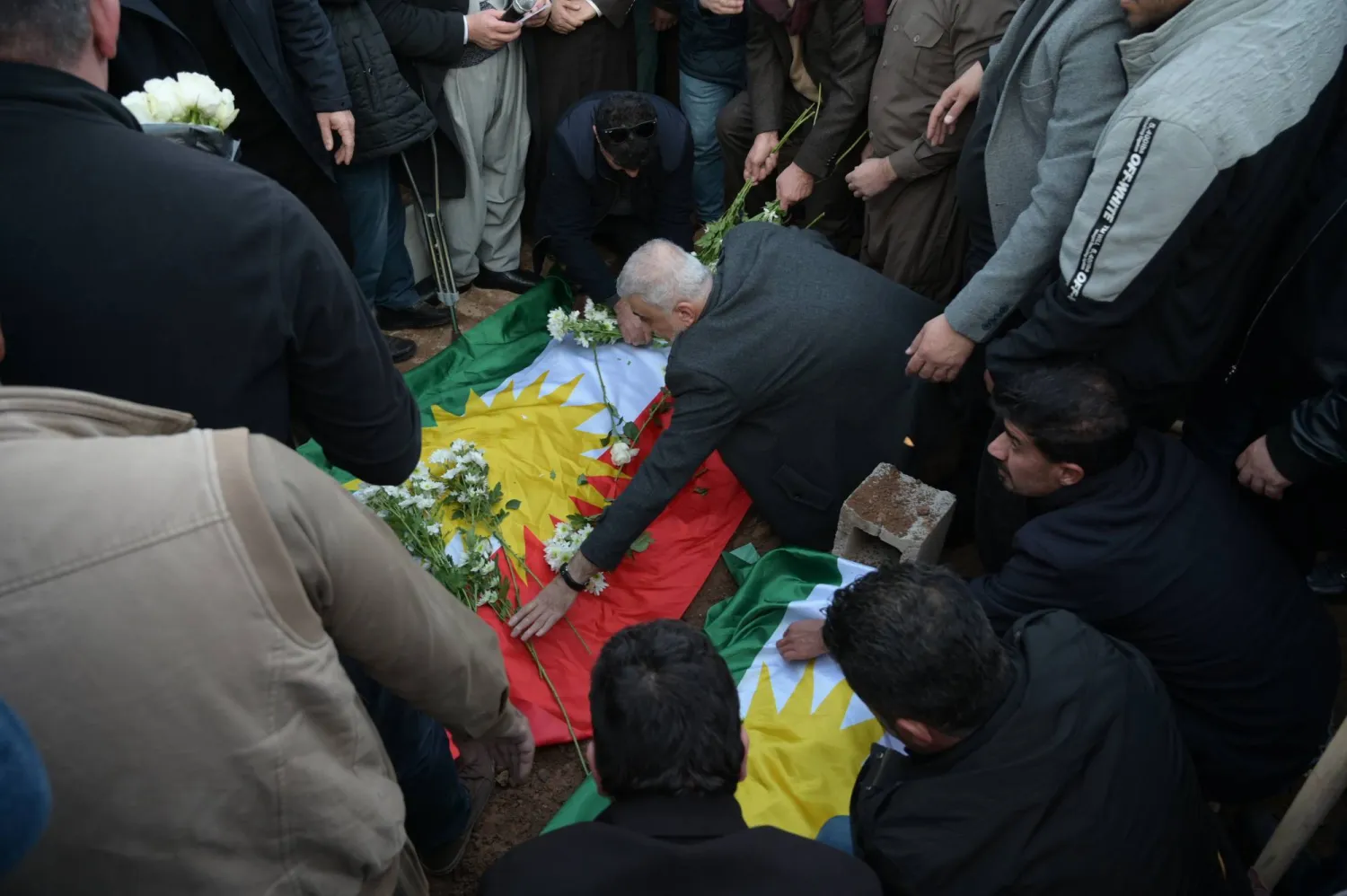 أشخاص يودّعون أقاربهم الذين قُتلوا في هجوم صاروخي ليلي استهدف مدينة أربيل شمال العراق (إ.ب.أ)