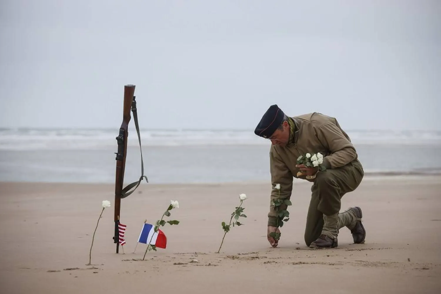 A World War II reenactor plants roses on Omaha Beach in Saint-Laurent-sur-Mer, Normandy, France, June 6, 2023. (AP)