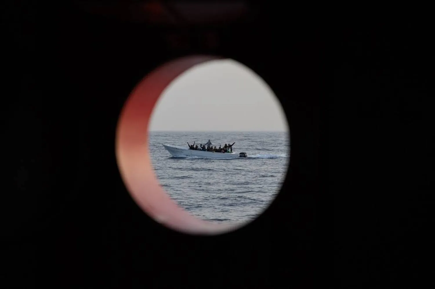 Migrants sailing in international waters aboard a small wooden boat are seen from the Spanish NGO Open Arms rescue vessel, on January 18, 2024 off the Libyan coast, in international waters of the central Mediterranean. (AFP)