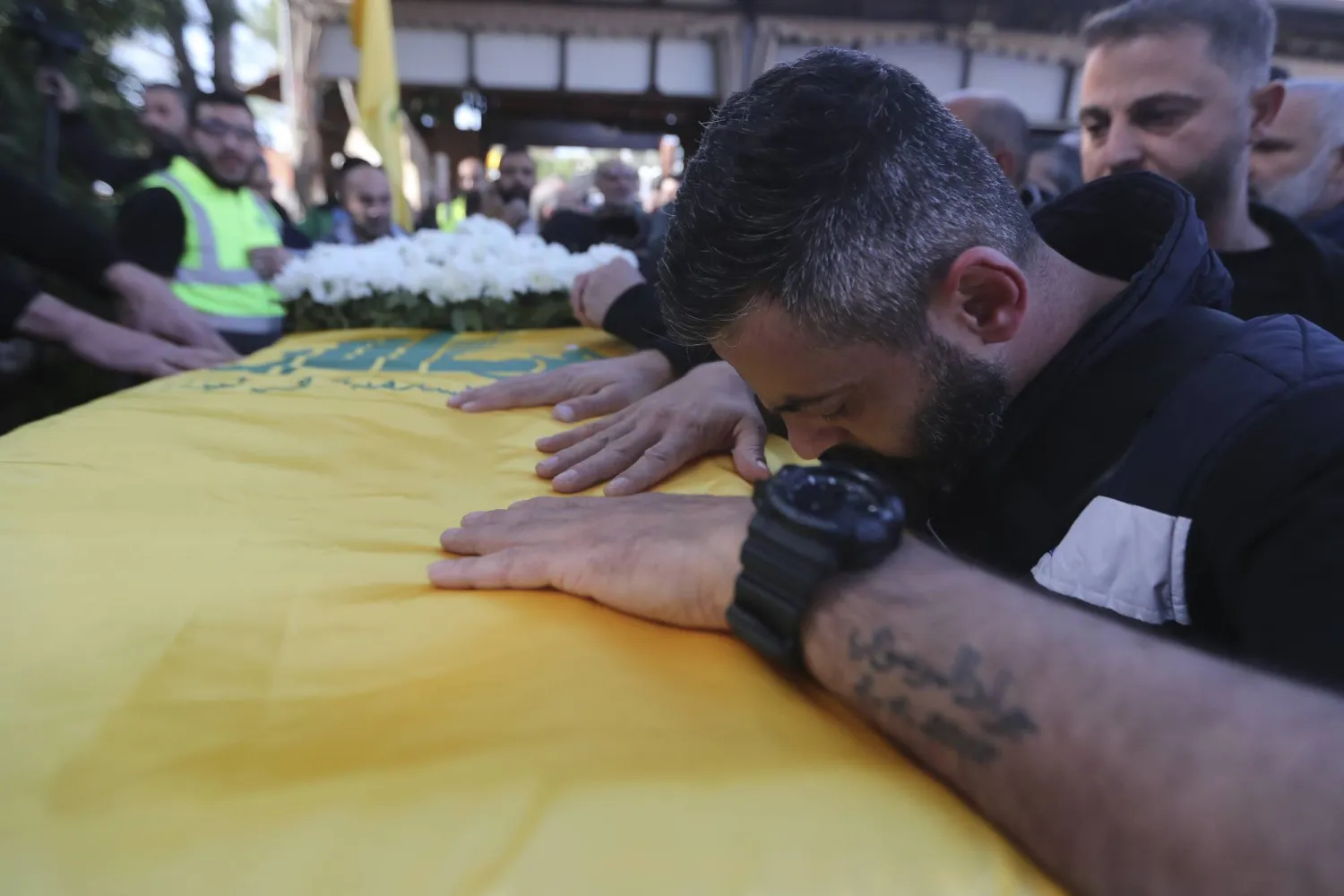 لبناني يبكي على نعش أمه خلال تشييعها في مدينة بنت جبيل بجنوب لبنان (أ.ب)