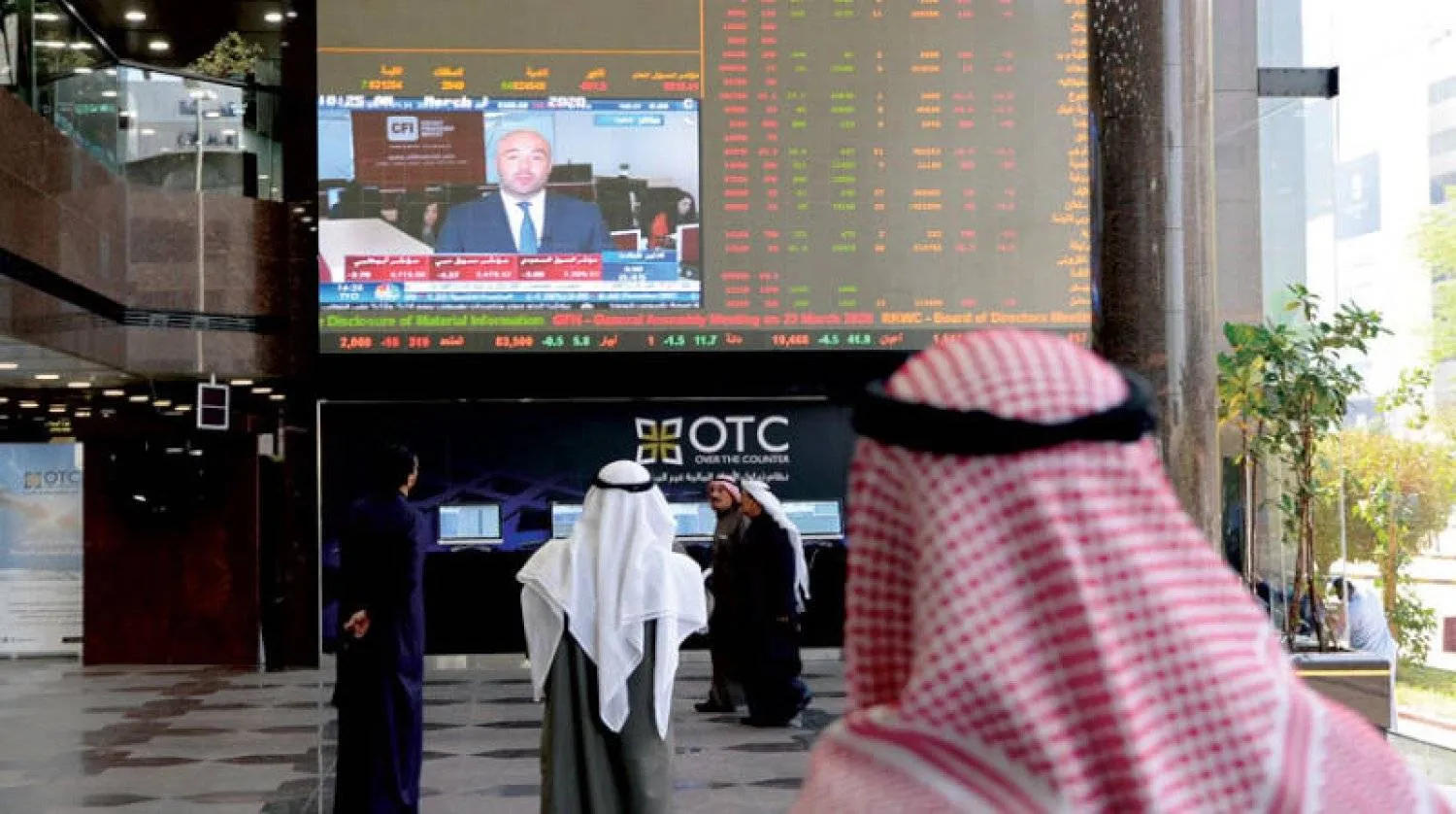 مستثمرون يتابعون شاشة لعرض أسعار الأسهم في الكويت (إ.ب.أ)