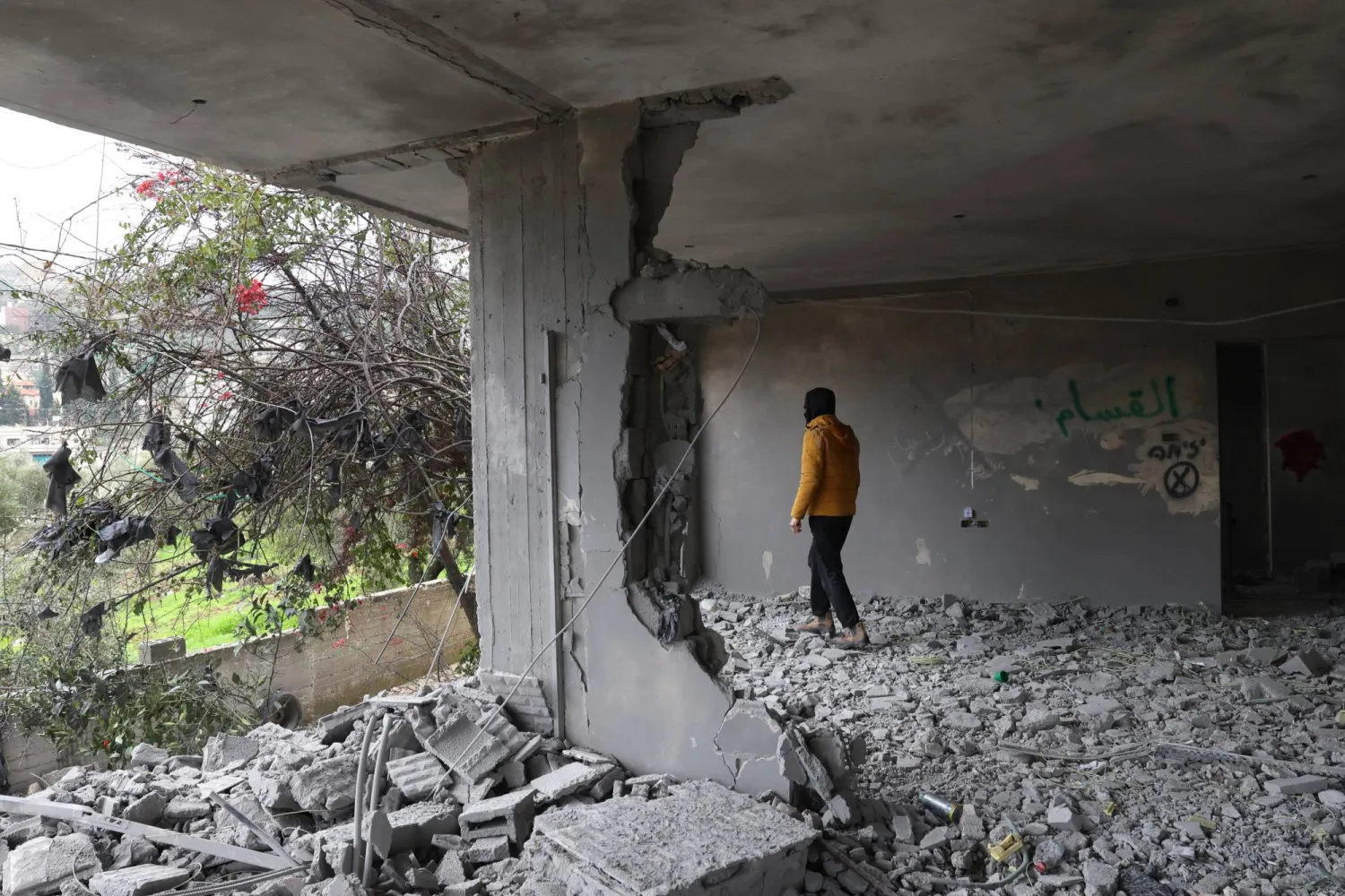 فلسطيني يتفقد الأضرار التي لحقت بمنزل باسل شحادة في قرية عوريف جنوب مدينة نابلس بالضفة الغربية (إ.ب.أ)