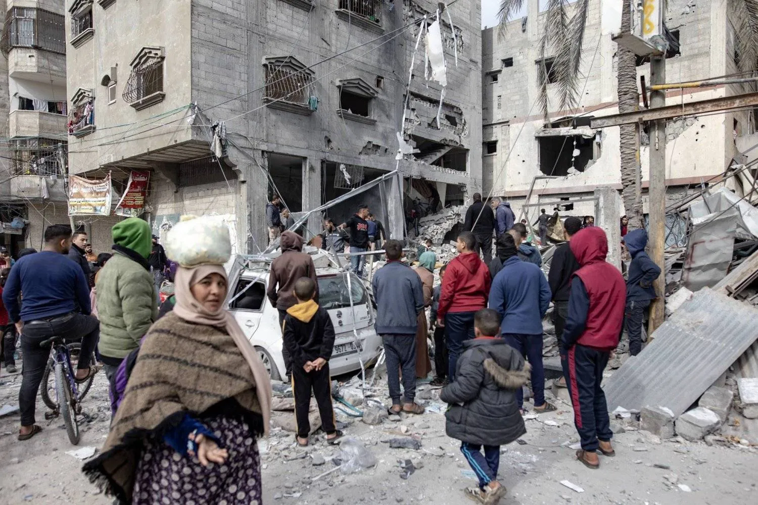 فلسطينيون يبحثون عن مفقودين تحت أنقاض المباني المدمَّرة جراء الغارات الجوية الإسرائيلية في خان يونس (إ.ب.أ)