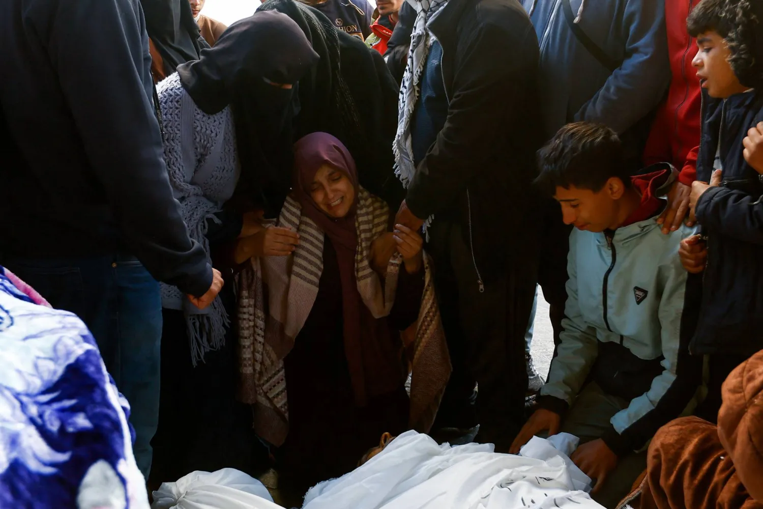 عائلة رجل فلسطيني توفي متأثراً بمرض القلب ولم يتلق العلاج الذي يحتاج إليه بسبب تدهور الأوضاع الصحية في مستشفى ناصر يبكونه بحرقة (رويترز)