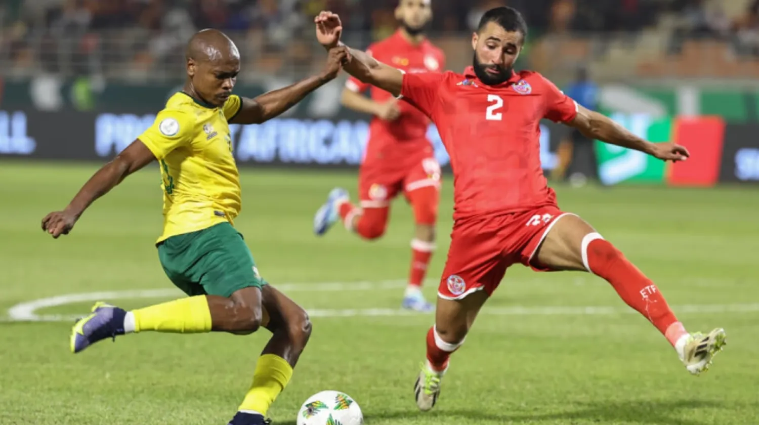 South Africa forward Percy Tau (left) crosses under pressure from Tunisian defender Ali Abdi © Fadel Senna, AFP
