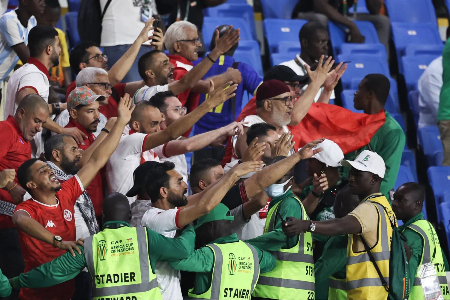 منظمو الملعب يحاولون السيطرة على جماهير تونس الغاضبة بعد الخروج المخيب (أ.ف.ب)