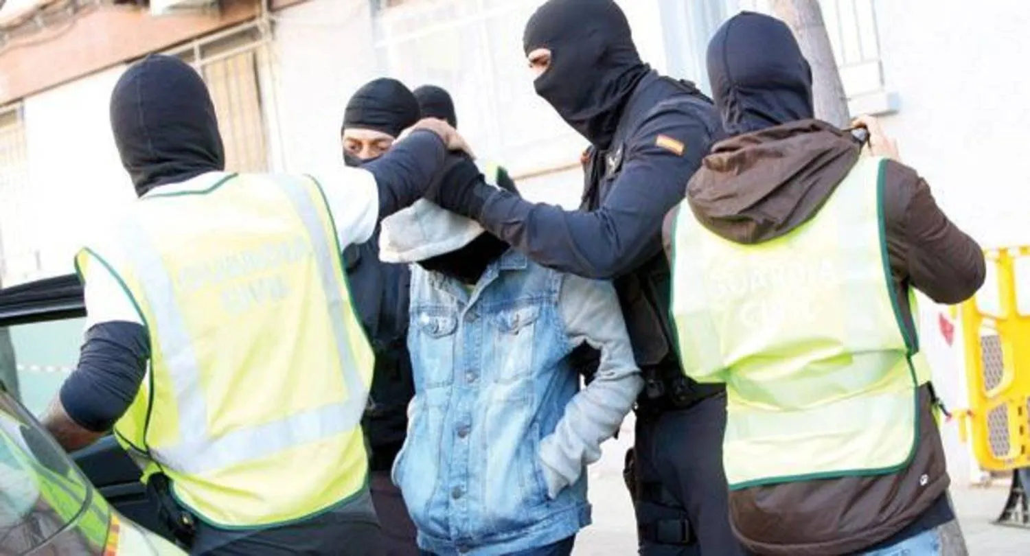 رجال أمن إسبان ملثمون خلال عملية توقيف مشتبهين بالإرهاب بينهم قُصّر في مدينة برشلونة عام 2015 (إ.ب.أ)