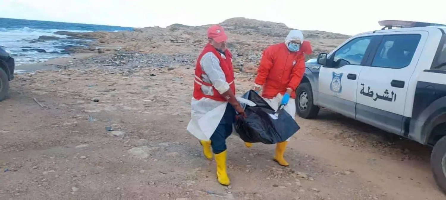 عناصر من «الهلال الأحمر» ينتشلون جثة قذفتها الأمواج إلى الشاطئ (الهلال الأحمر بمصراتة)