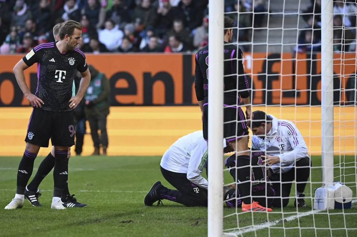  Munich's Kingsley Coman, 2nd right, receives medical treatment during the Bundesliga soccer match between FC Augsburg and Bayern Munich at the WWK-Arena, Augsburg, Germany, Saturday Jan. 27, 2024. (dpa via AP)
