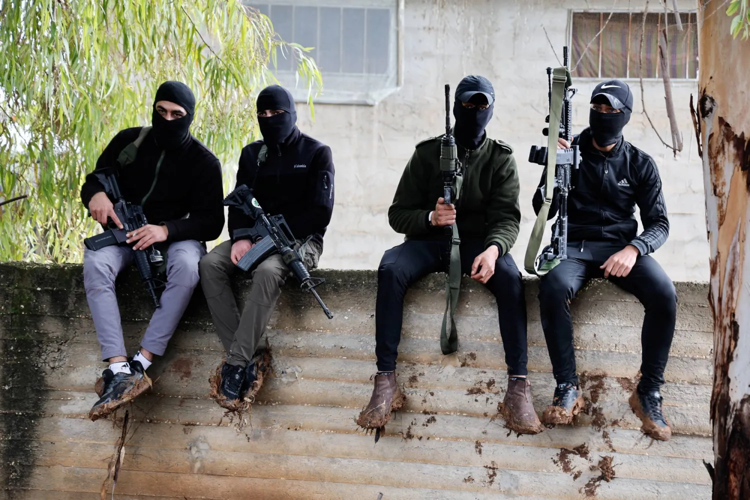 مسلحون فلسطينيون خلال تشييع جثمان فلسطيني قُتل في مداهمة لقوات الاحتلال الإسرائيلي قرب جنين (رويترز)