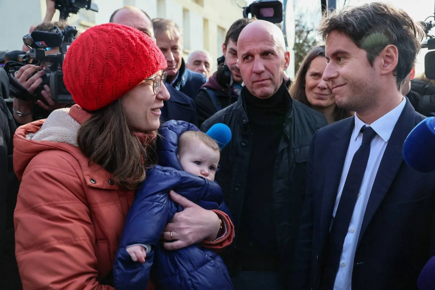 رئيس الحكومة غابريال أتال يتحدث مع مواطنة في بدلة لاريش القريبة من مدينة تور الأحد سعياً لتهدئة غضب المزارعين (أ.ف.ب)