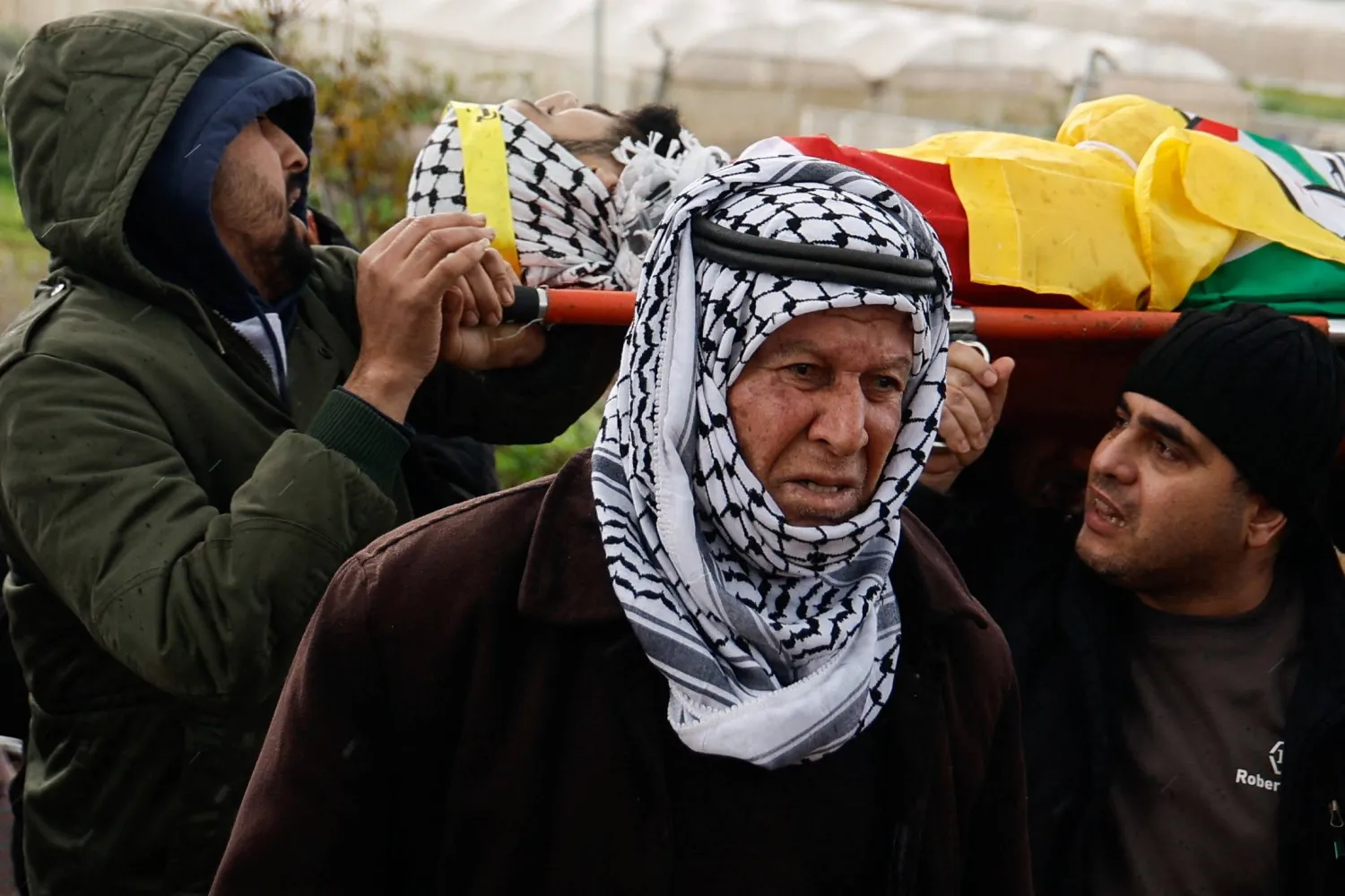 فلسطيني يشارك بجنازة مقاتل فلسطيني قُتل في هجوم إسرائيلي بجنين (رويترز)