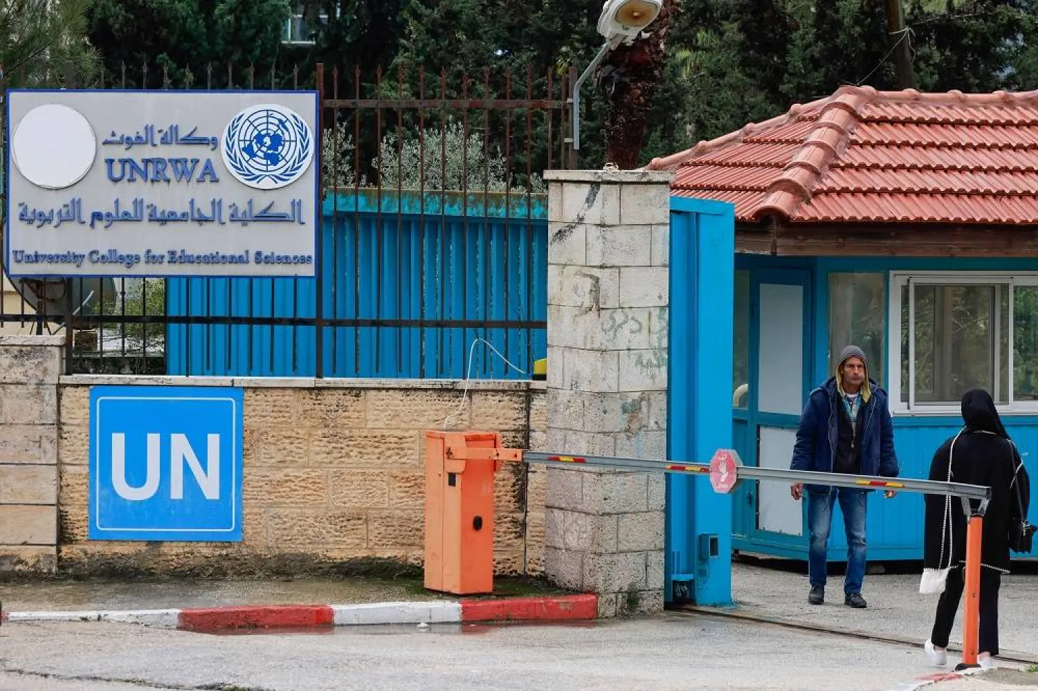 Palestinians stand at the entrance of the UNRWA-run University College for Educational Science Ramallah city in the occupied West Bank on January 29, 2024. (AFP)