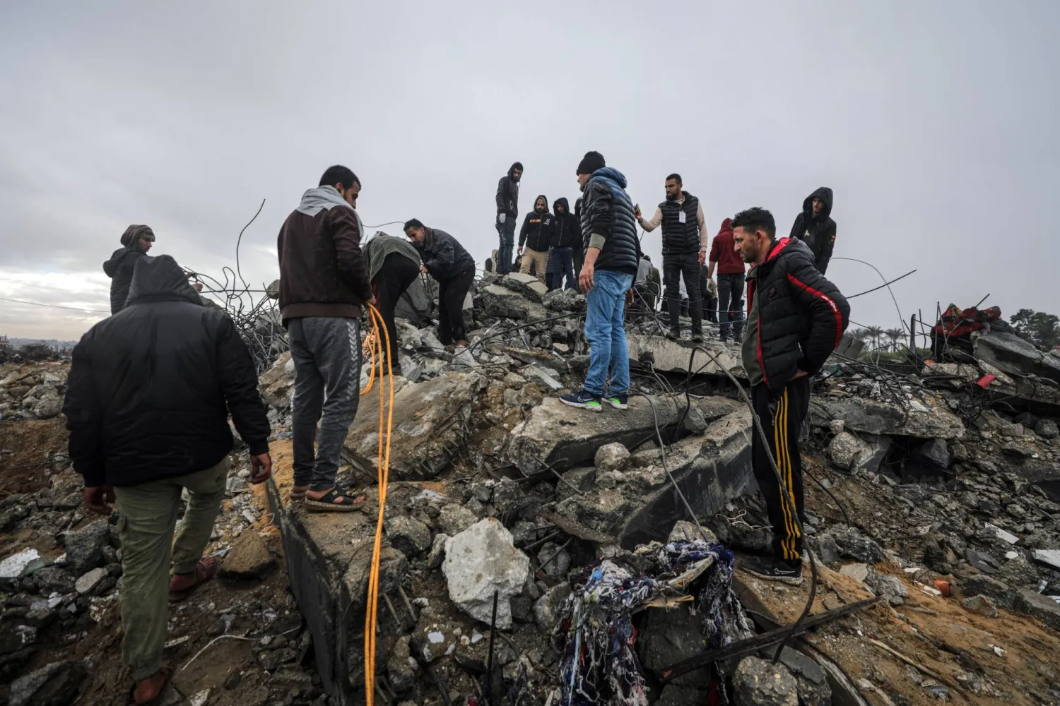 فلسطينيون يبحثون بين أنقاض مبنى مدمر بعد غارات إسرائيلية في دير البلح بقطاع غزة في 29 يناير 2024 (إ.ب.أ)
