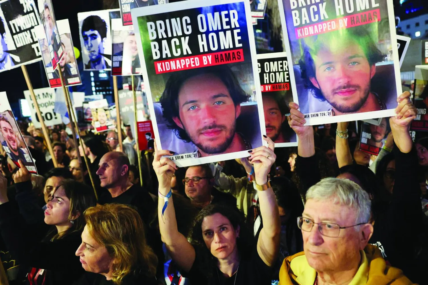 متظاهرون يرفعون صور الرهائن المحتجزين لدى «حماس» (رويترز)