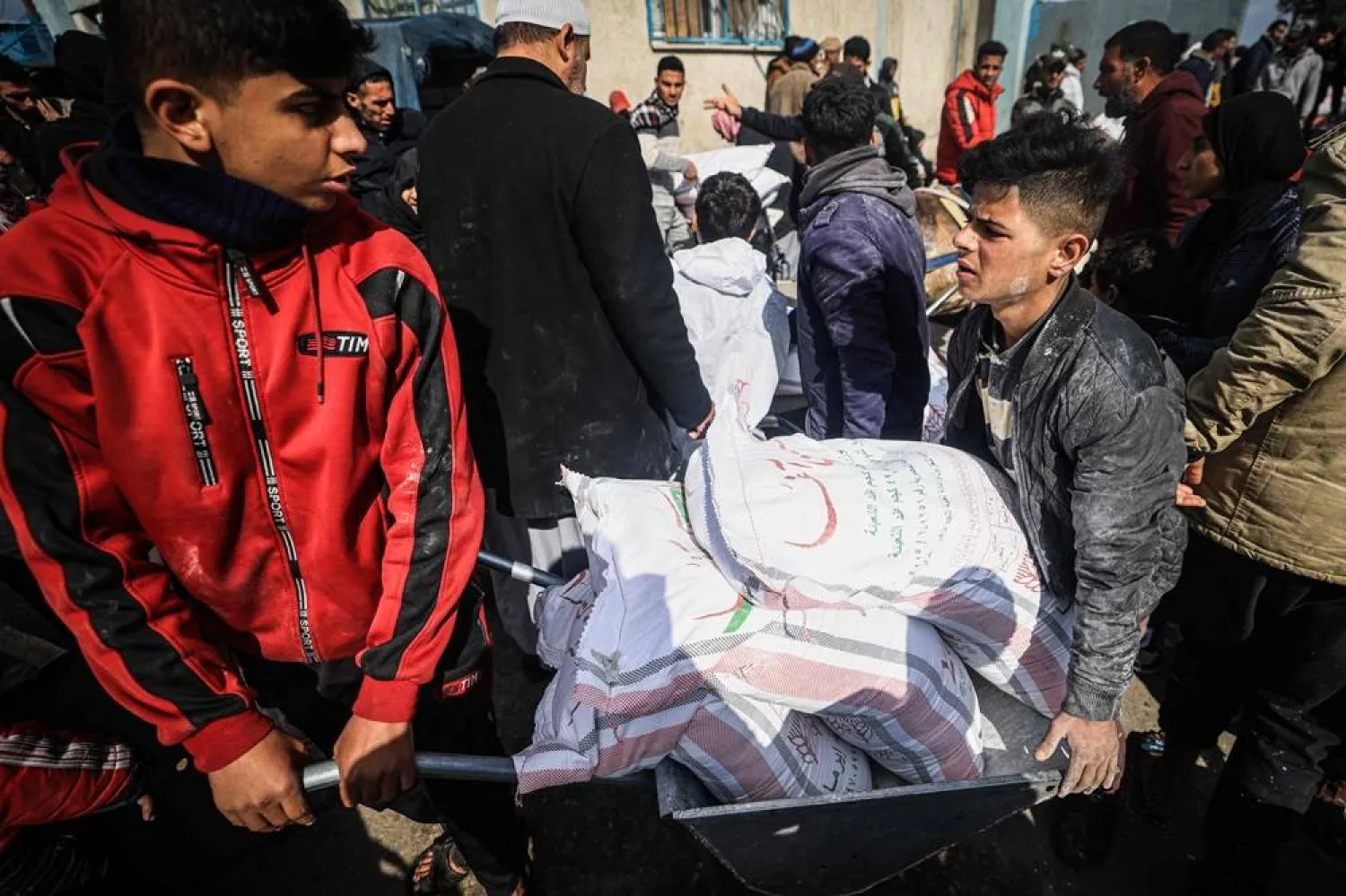 Displaced Palestinians receive food aid at the United Nations Relief and Works Agency for Palestine Refugees (UNRWA) center in Rafah in the southern Gaza Strip on January 28, 2024, amid ongoing battles between Israel and the Palestinian militant group Hamas. (AFP)