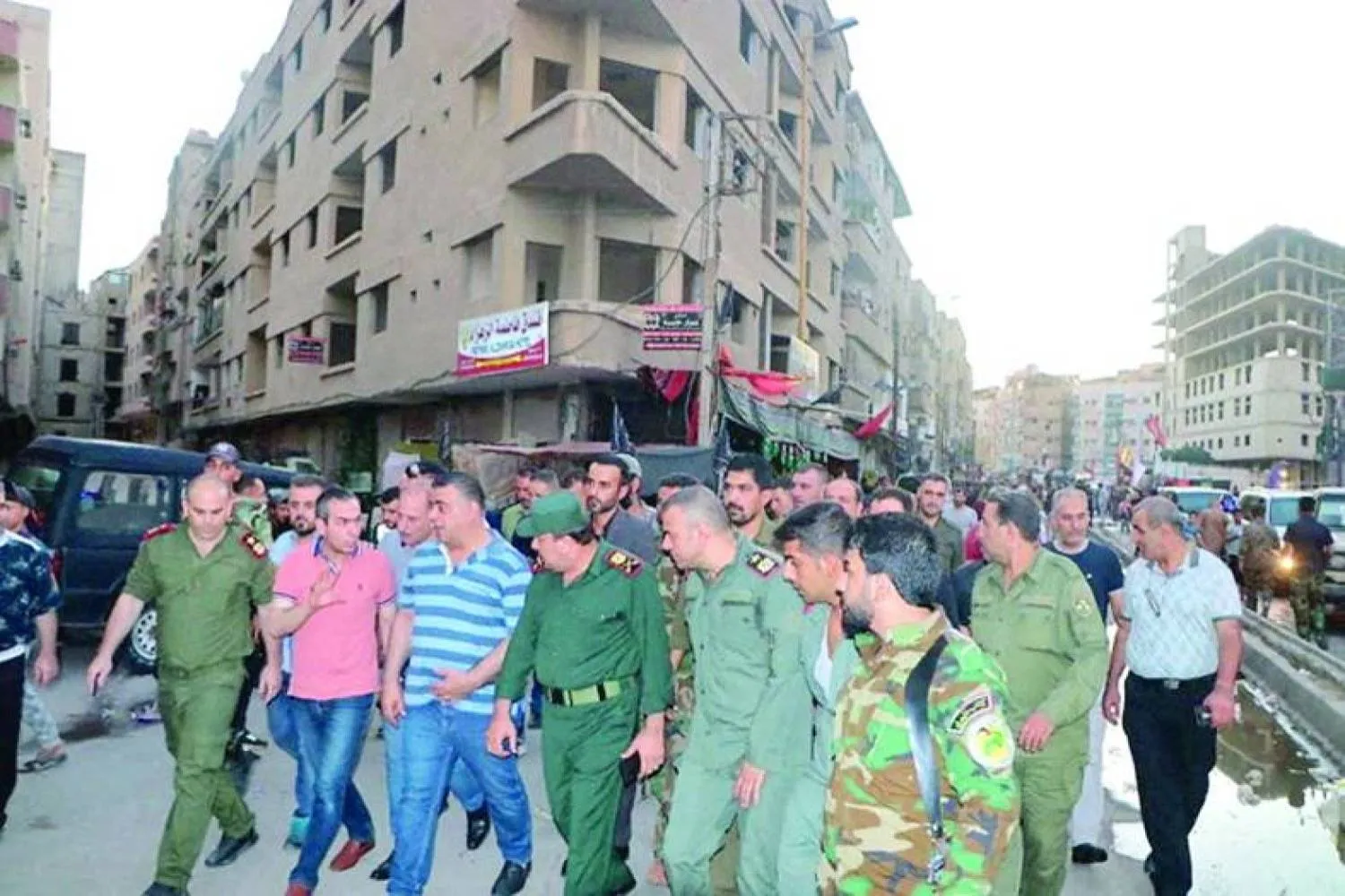 Syrian officers inspect the site of an explosion in Sayyida Zainab last July (Reuters)