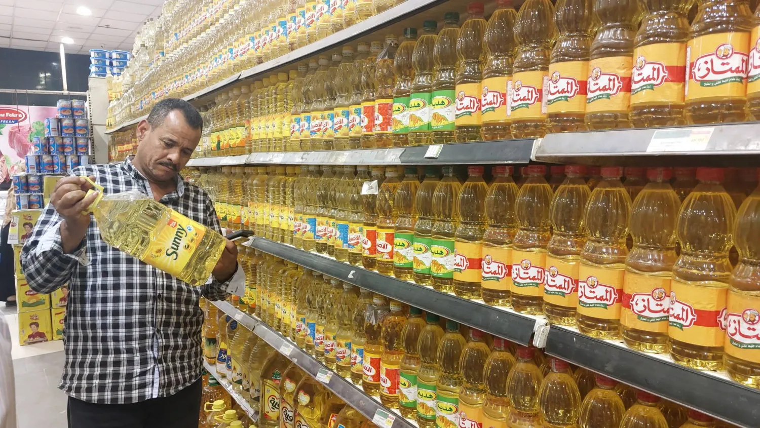 مصري يطالع سعر السلع في أحد المراكز التجارية بالقاهرة قبل الشراء (الشرق الأوسط)