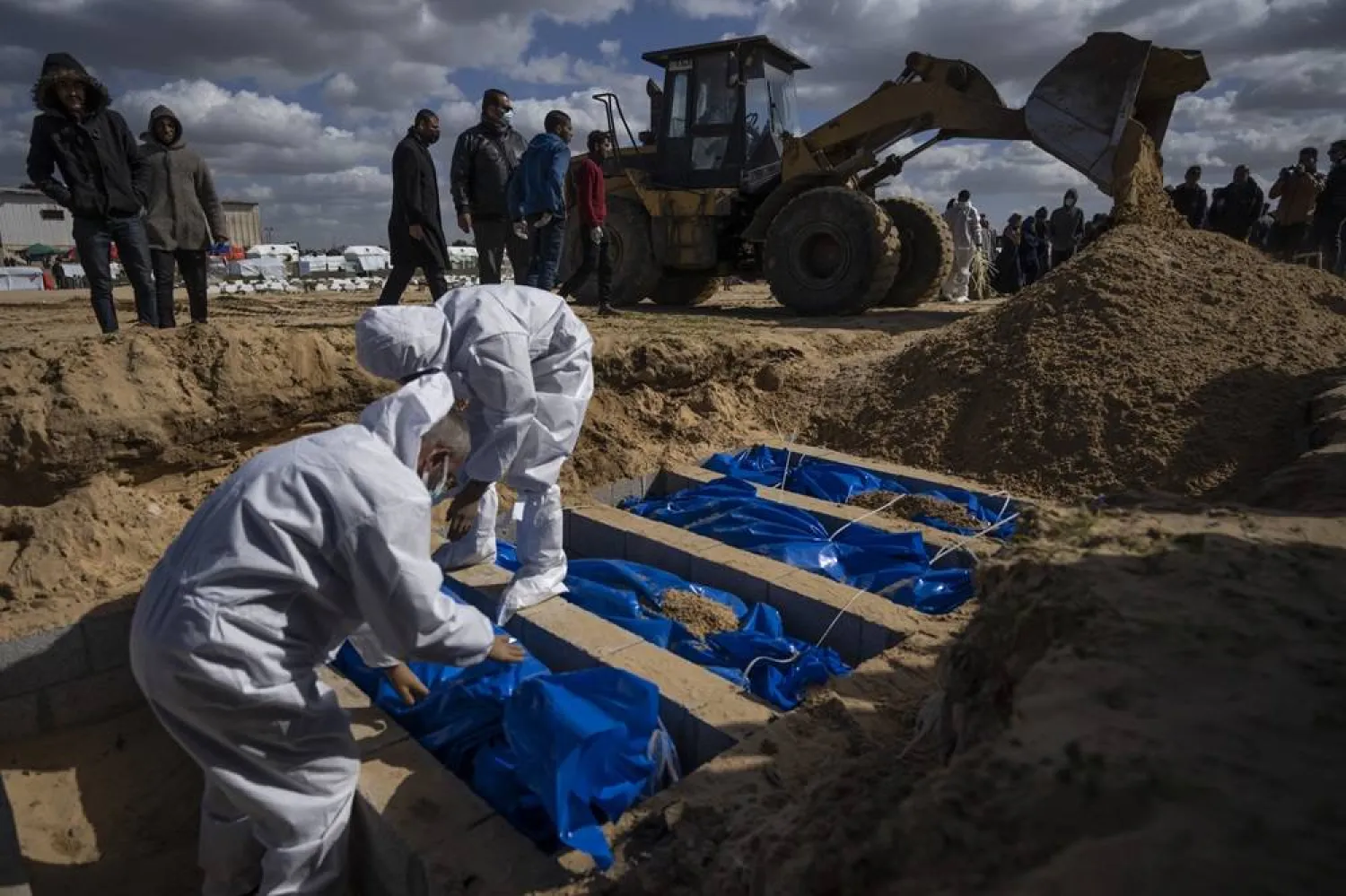  Palestinians bury the bodies of people who were killed in fighting with Israel and returned to Gaza by the Israeli military, during a mass funeral in Rafah, Gaza Strip, Tuesday, Jan. 30, 2024. (AP)