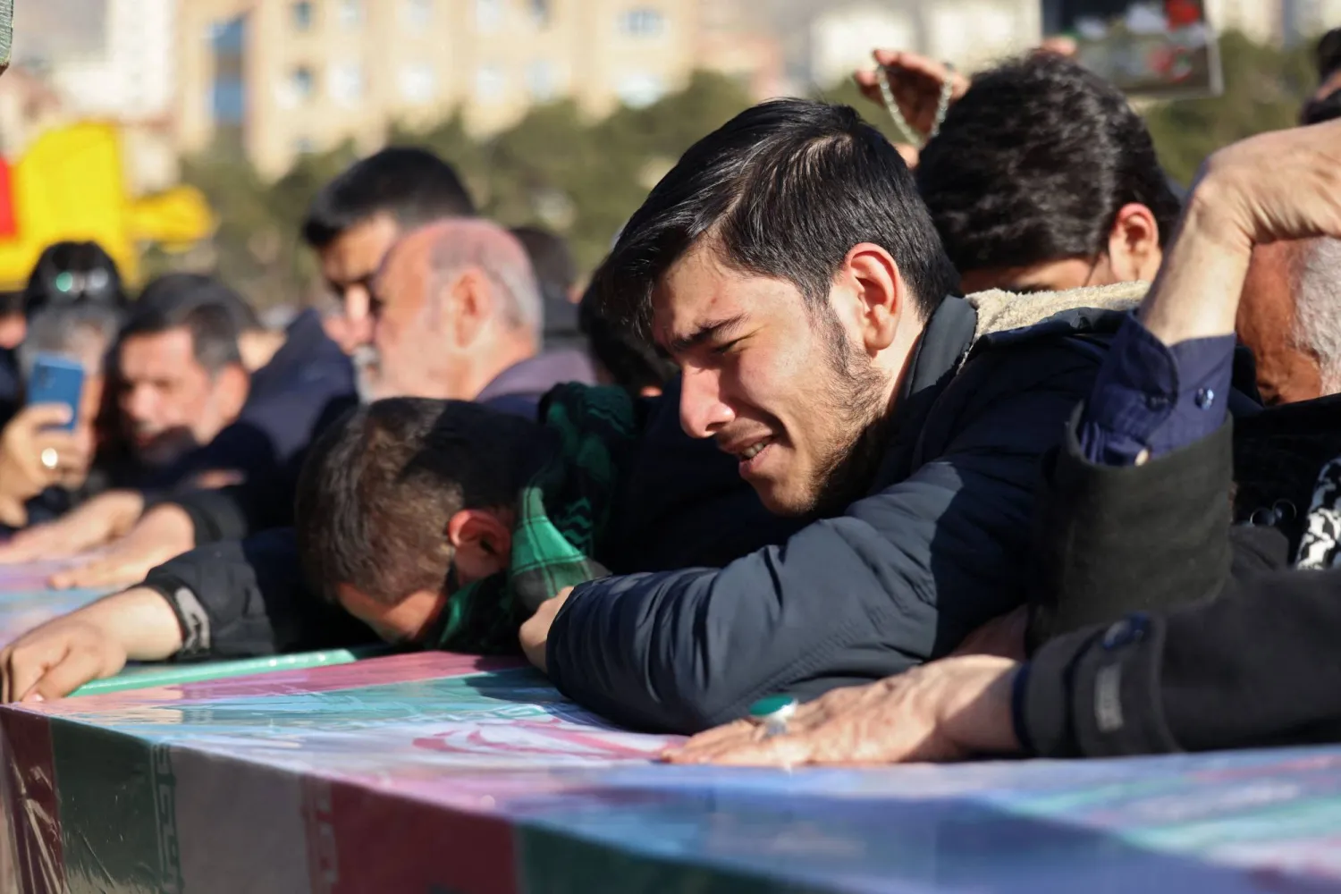 People mourn over the coffins of Iranian Revolutionary Guard Corps (IRGC) members killed in Damascus in a strike blamed on Israel on January 20, during their funeral in the Iranian capital Tehran on January 22, 2023. (Photo by ATTA KENARE / AFP)