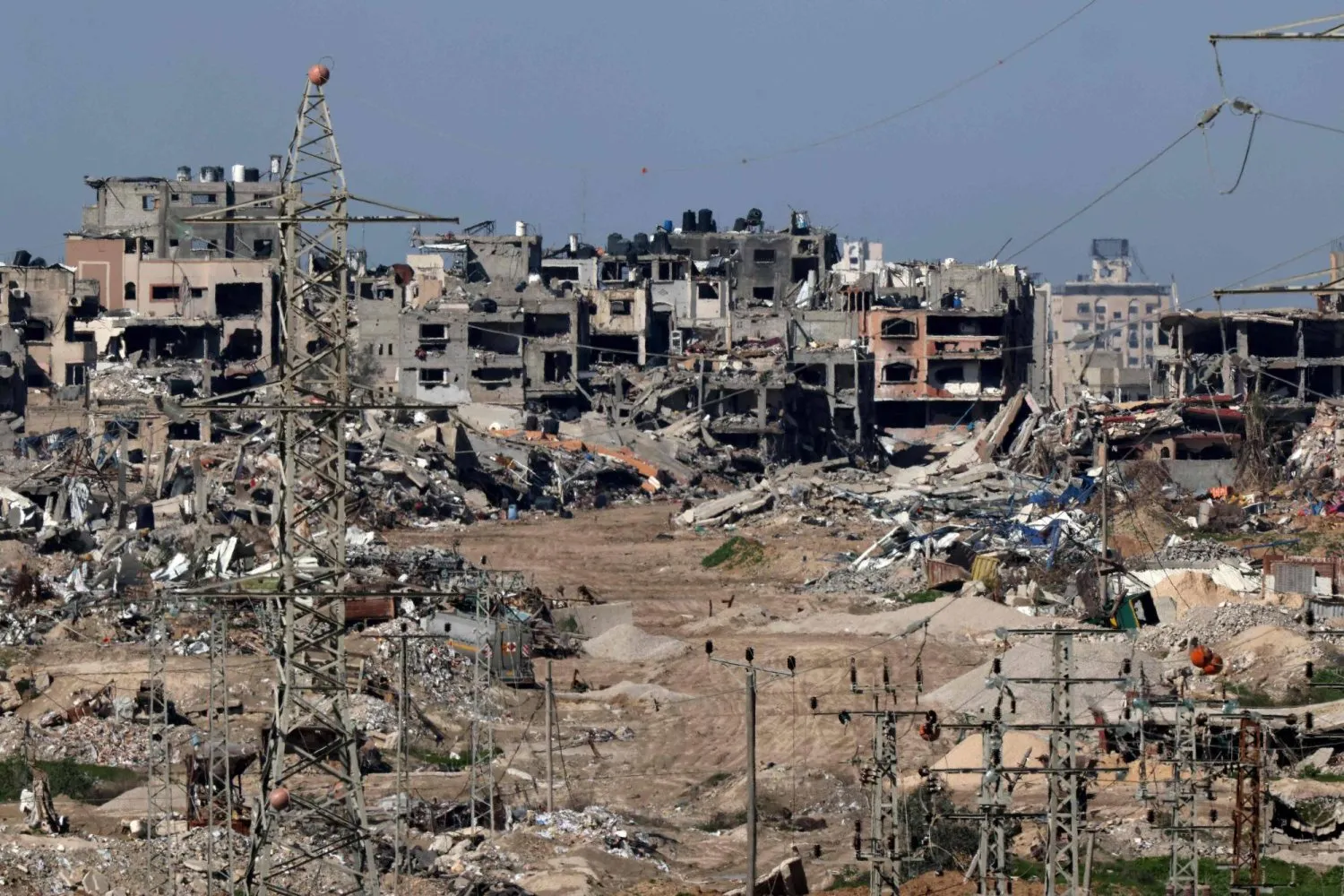 Şubat 2024'te İsrail'in güneyinden çekilen bir fotoğraf, İsrail ile Hamas arasında devam eden çatışmalar sırasında Gazze Şeridi'nde yıkılan binaları gösteriyor (AFP)