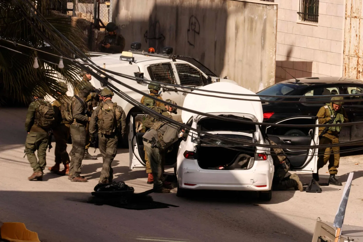 قوات إسرائيلية تفحص سيارة قيل إن فلسطينياً استخدمها لتنفيذ هجوم دهس تم إحباطه ضد القوات المتمركزة بالقرب من مستوطنة على مشارف مدينة الخليل (أ.ف.ب)