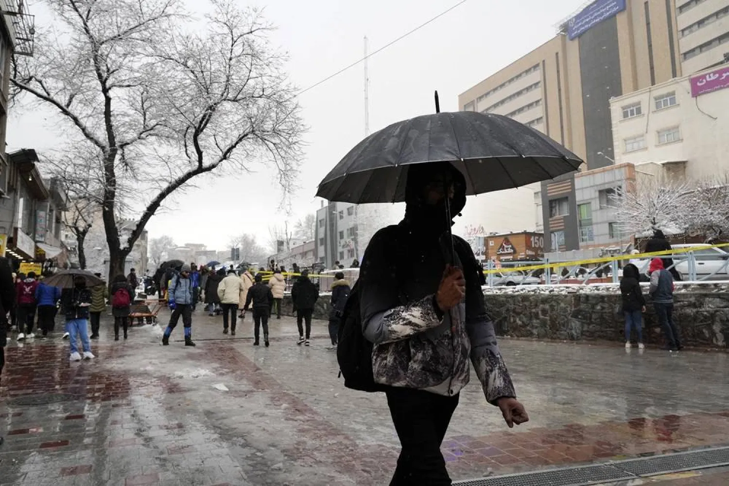  A man uses umbrella as he walks on a sidewalk during snowy weather in northern Tehran, Iran, Friday, Feb. 2, 2024. (AP)
