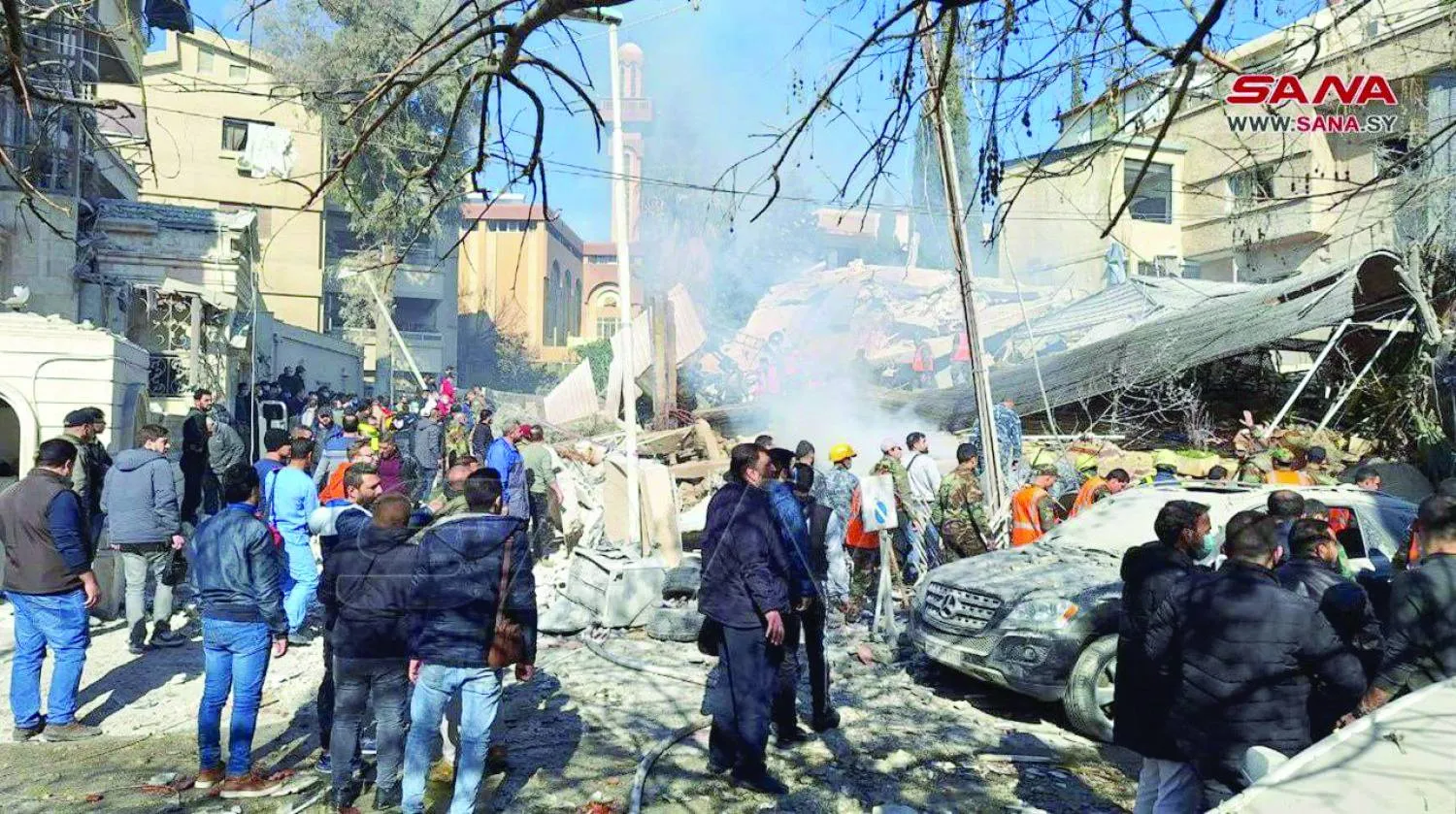 
سكان حي المزة فيلات بدمشق يتفقدون الأضرار في موقع الغارة الإسرائيلية على مبنى تابع لـ«الحرس الثوري» 20 يناير (رويترز)