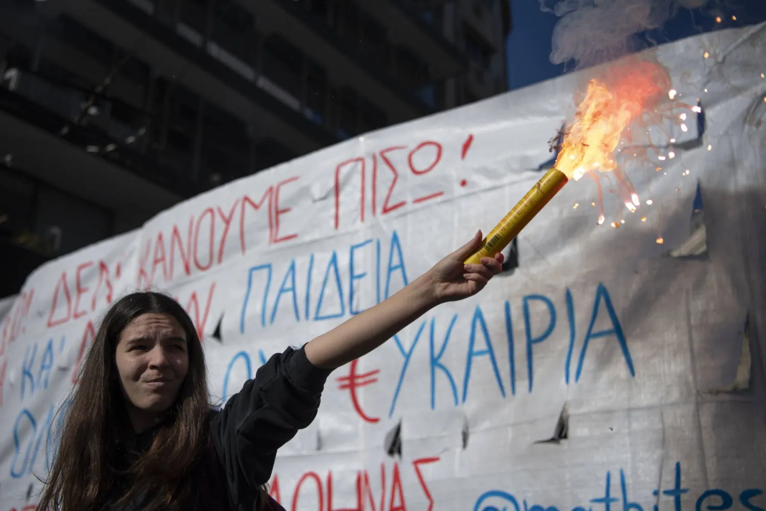 A student holds a flare during a demonstration against plans by Greece's conservative government to legalize privately-run universities, in Athens, Thursday, Feb. 1, 2024. (AP Photo/Michael Varaklas)