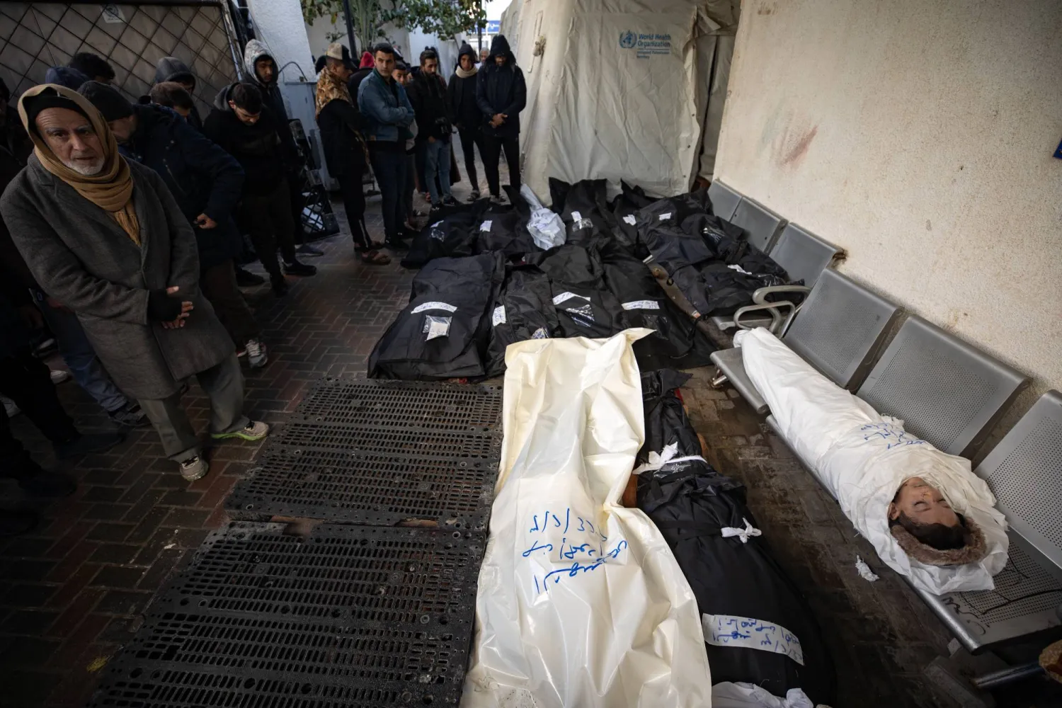 مشيعون بجوار الجثث داخل مستشفى النجار بمخيم رفح بعد غارة جوية إسرائيلية استهدفت منزلين وأدت إلى استشهاد 16 شخصاً في مخيم رفح جنوب قطاع غزة (إ.ب.أ)
