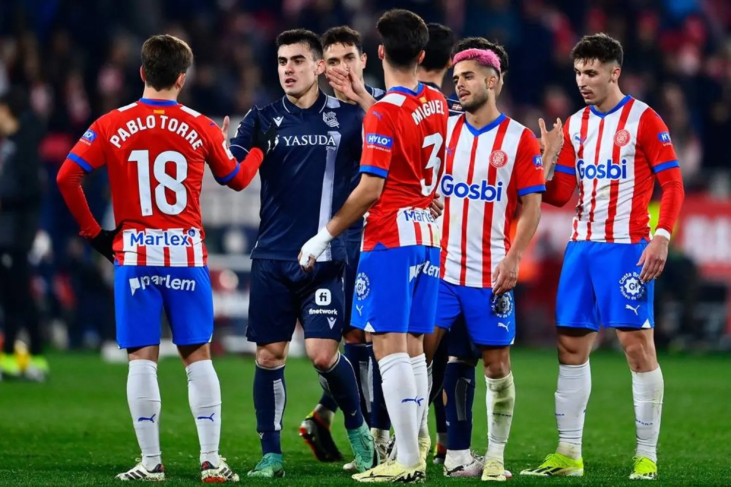  Real Sociedad's Spanish forward #07 Ander Barrenetxea greets Girona's Spanish midfielder #18 Pablo Torre at the end of the Spanish league football match between Girona FC and Real Sociedad at the Montilivi stadium in Girona on February 3, 2024. (AFP)