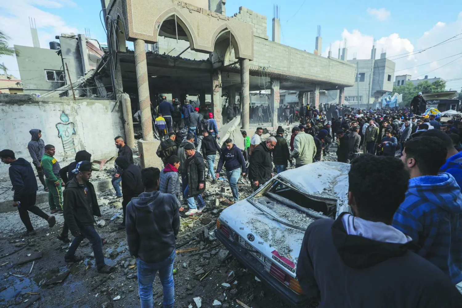 
فلسطينيون يبحثون عن مفقودين تحت أنقاض مسجد مدمر في دير البلح بقطاع غزة بعد غارة جوية إسرائيلية أمس (إ.ب.أ)