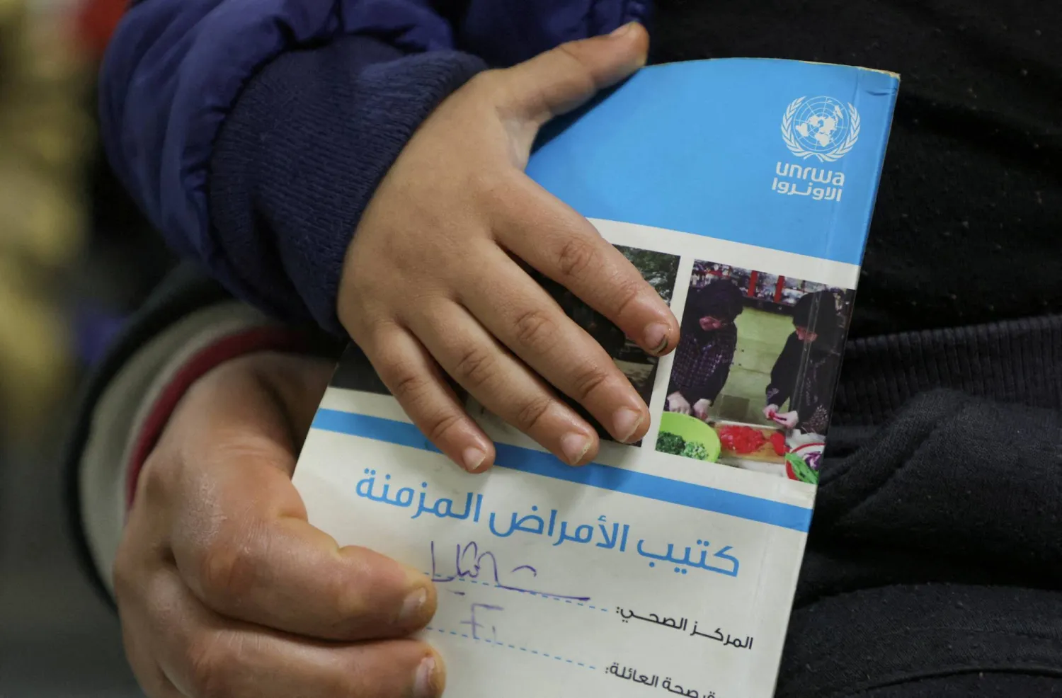 FILE PHOTO: A child holds a booklet as he waits inside a United Nations Relief and Works Agency (UNRWA) health center at Shatila Palestinian refugee camp, in Beirut suburbs, Lebanon January 30, 2024. REUTERS/Mohamed Azakir//File Photo
