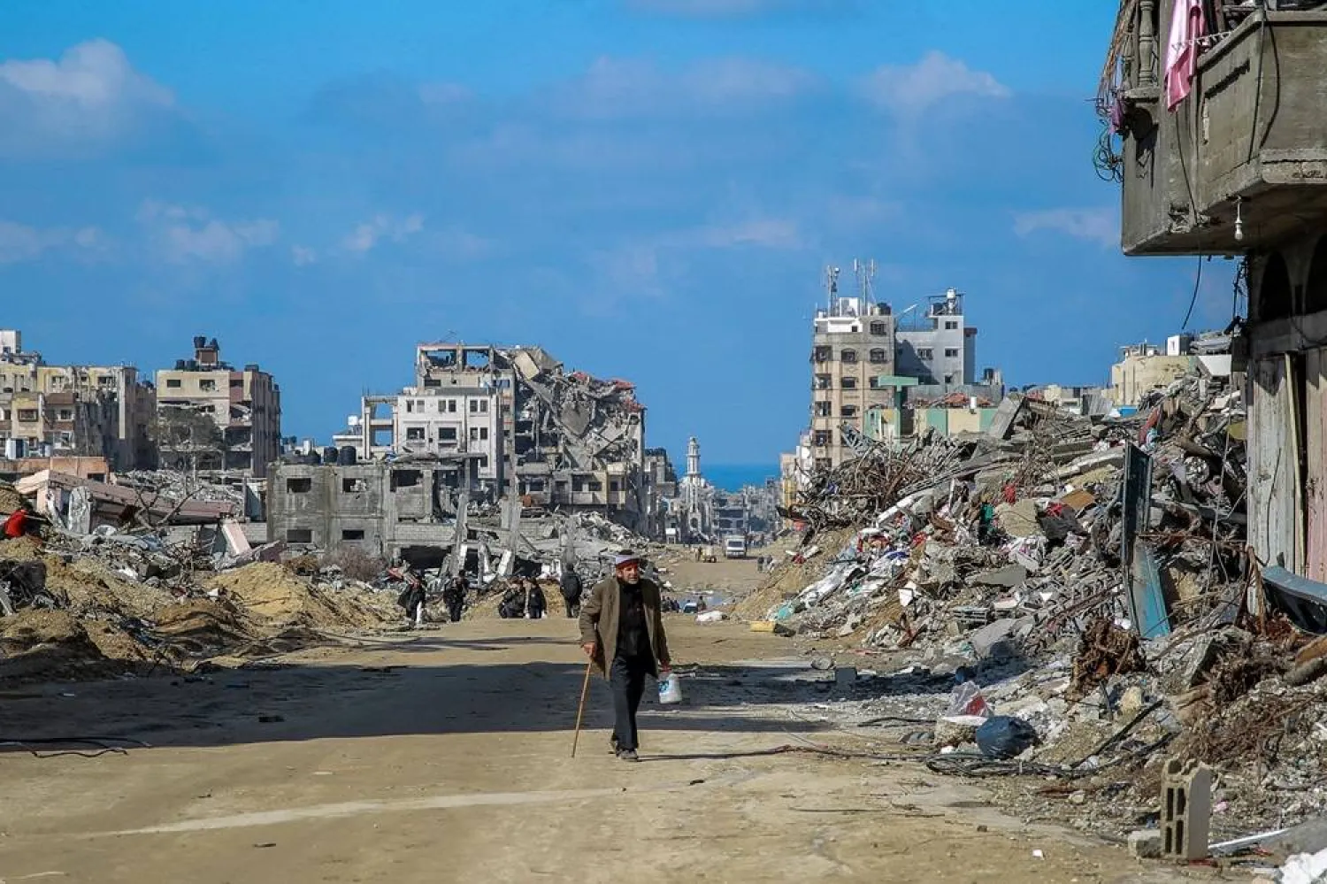 People walk on Al-Oyoun Street amid the rubble of buildings destroyed during Israeli bombardment on Gaza City on February 3, 2024, as battles continue between Israel and the Palestinian militant group Hamas. (AFP)