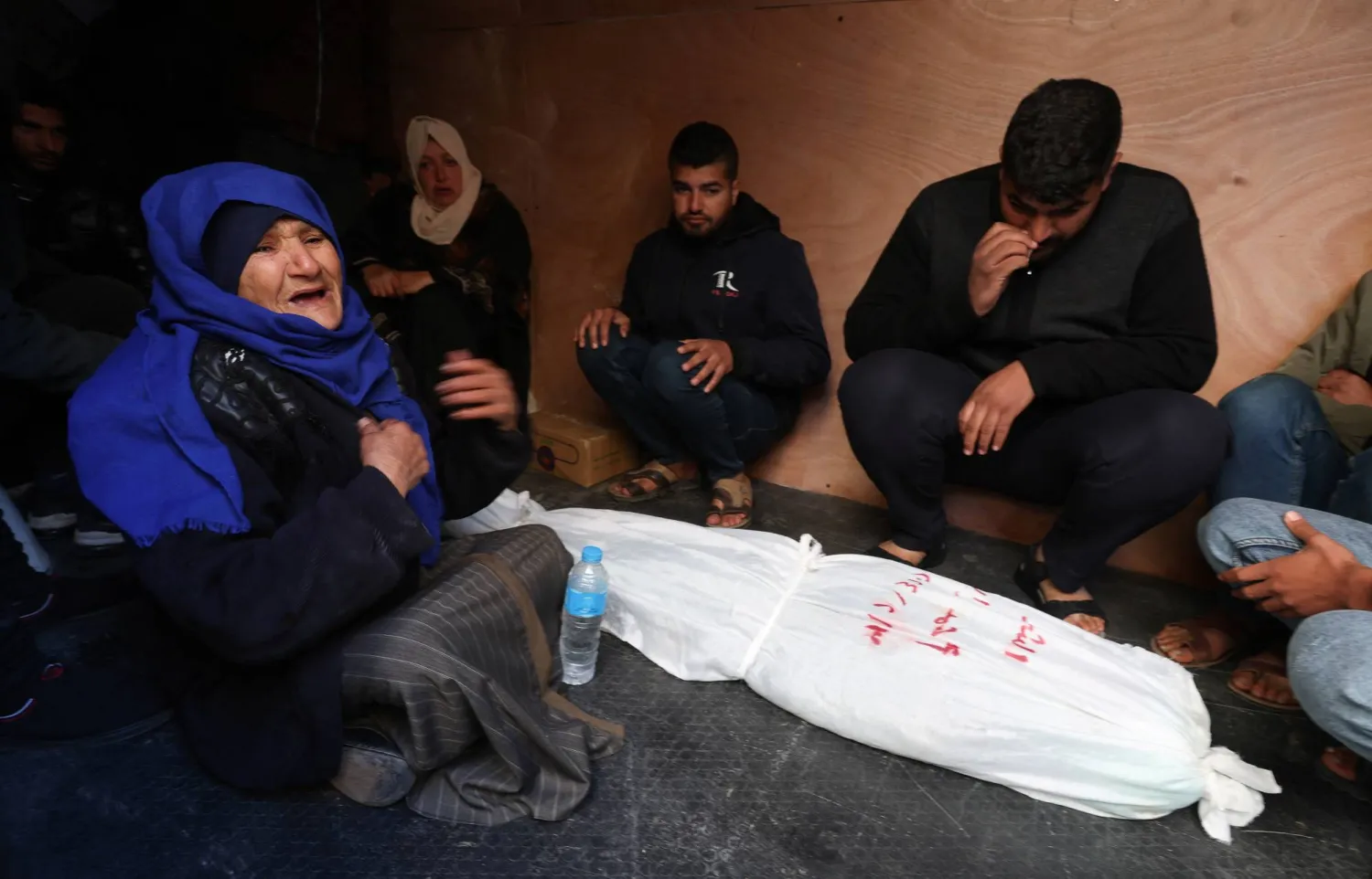 أسرة طفل فلسطيني تبكي بجانب جثته بعد أن قُتل في غارات إسرائيلية في رفح جنوب قطاع غزة (رويترز)