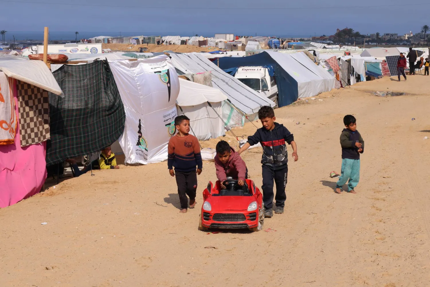 أطفال نازحون يلعبون في مدينة رفح على الحدود بين غزة ومصر (رويترز)