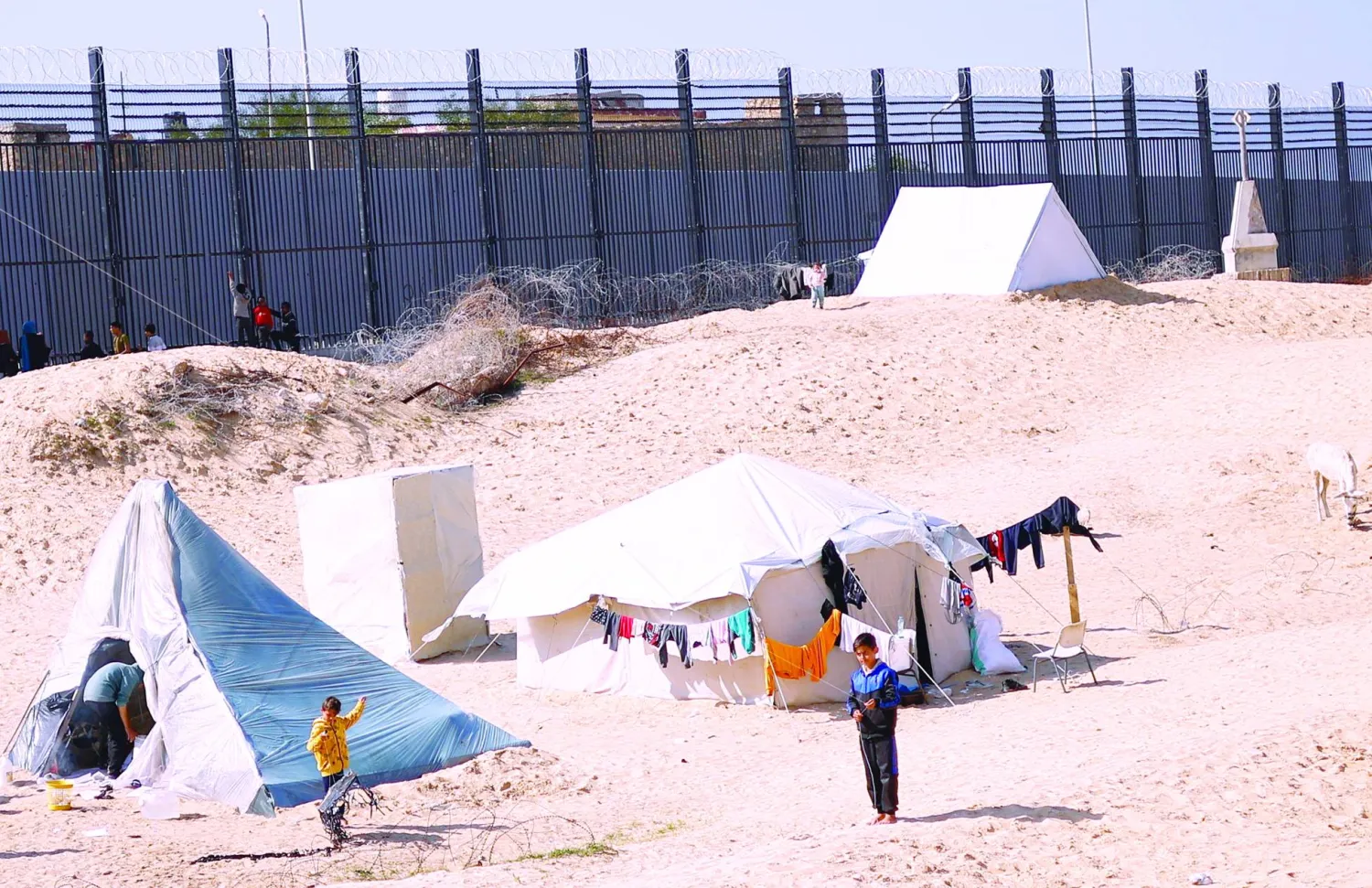 
نازحون فلسطينيون أمام خيامهم في رفح بجنوب غزة أمس (رويترز) وفي الإطار الرئيس الفلسطيني محمود عباس لدى لقائه وزير الخارجية الأميركي أنتوني بلينكن في رام الله أمس (إ.ب.أ)