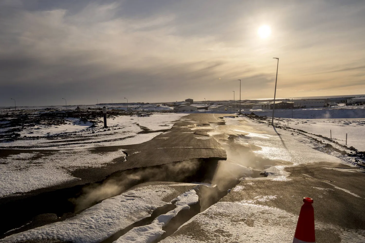 Steam rises from fissures in the roads damaged during January's volcanic eruption in the town of Grindavik, Iceland, Tuesday, Feb. 6, 2024. (AP Photo/ Marco Di Marco)