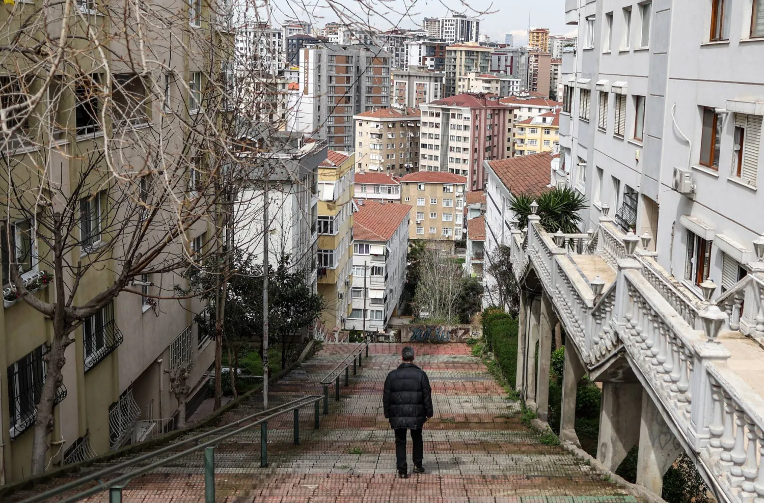 A man walks amid apartment buildings of the Maltepe district, Istanbul, Turkey, 03 April 2023. (Issued 05 February 2024)  EPA/ERDEM SAHIN