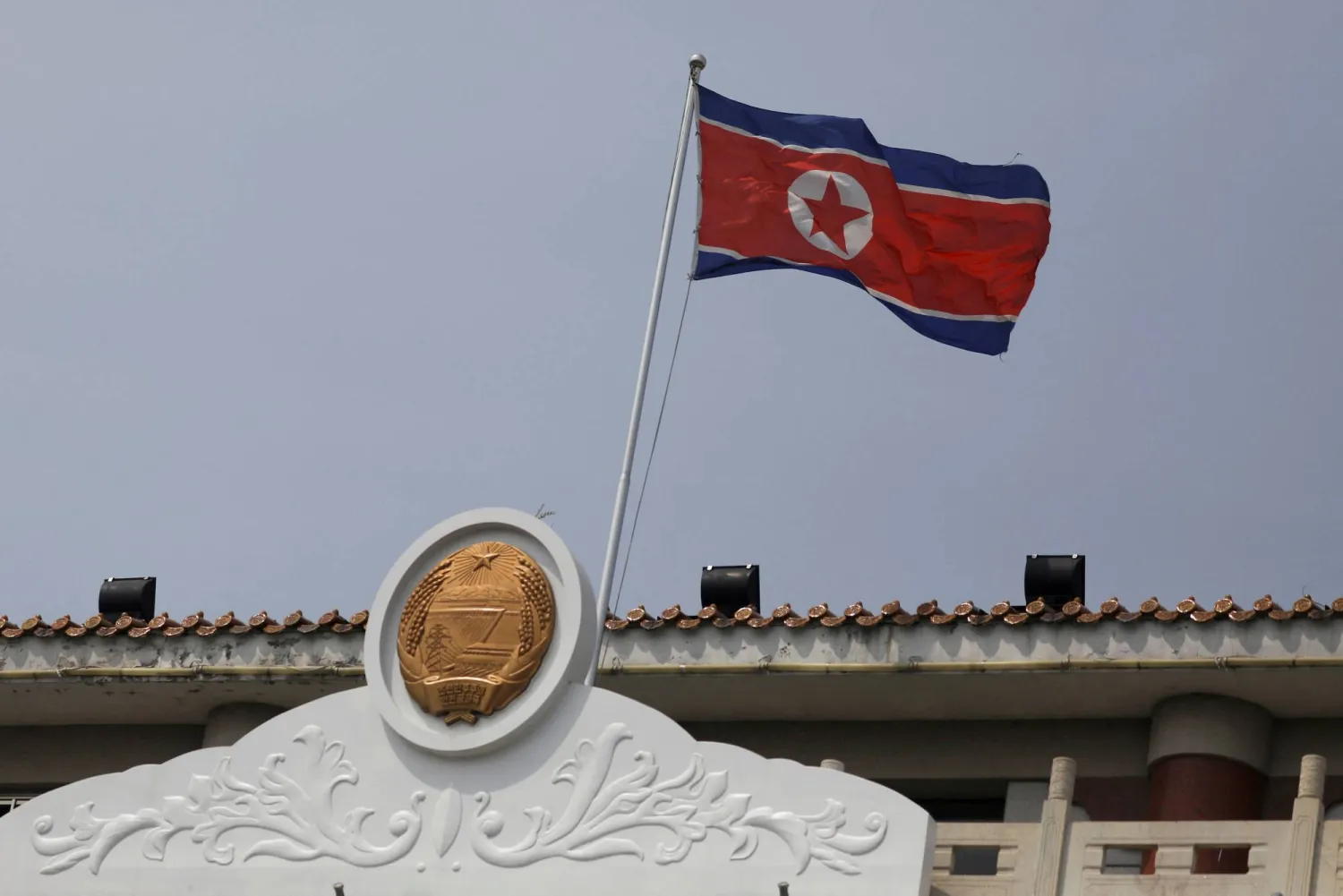 FILE PHOTO: The North Korean flag flutters at the North Korea consular office in Dandong, Liaoning province, China April 20, 2021. REUTERS/Tingshu Wang/File Photo