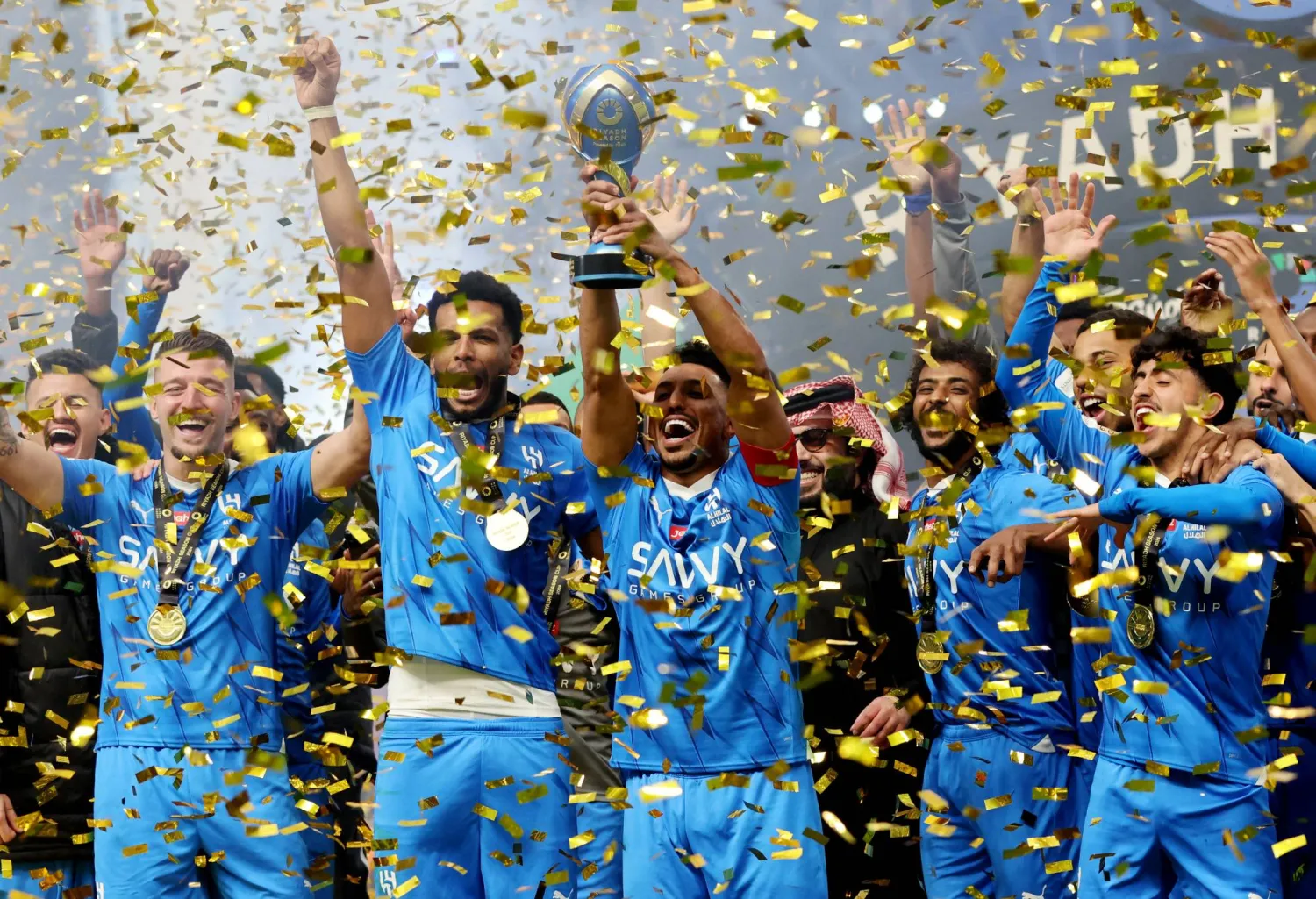قائد الهلال سالم الدوسري يرفع كأس البطولة عالياً (رويترز)