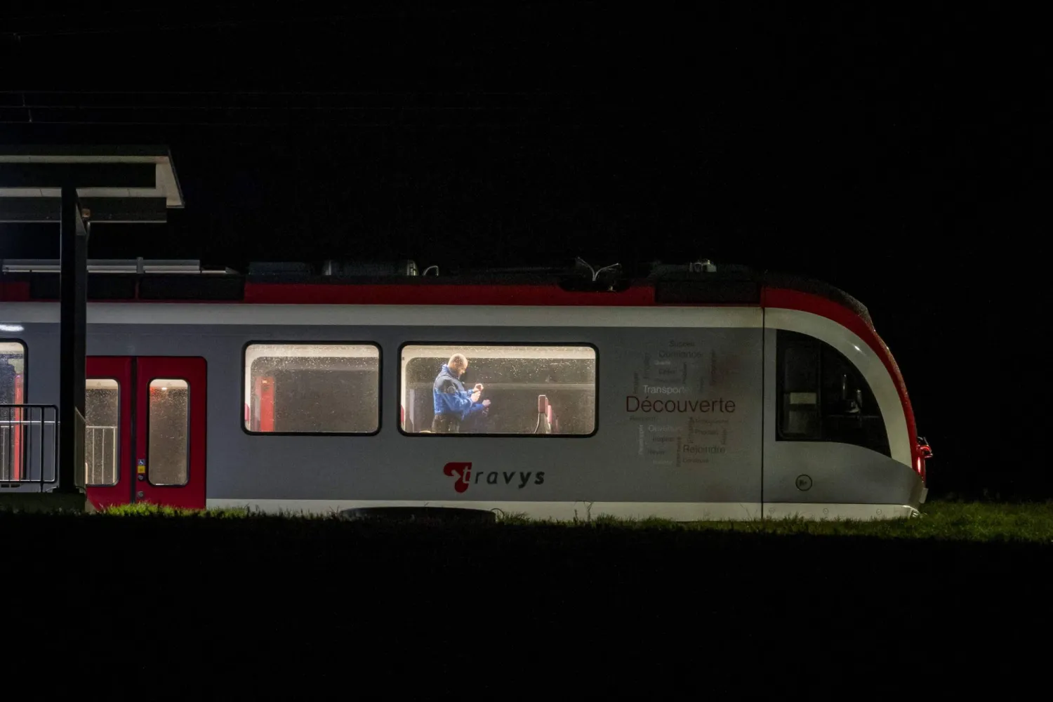 A Swiss Gendarme Police officer inspects the inside of a train, where passengers travelling from Yverdon to Sainte-Croix were earlier held hostage, in Essert-Sous-Champvent, western Switzerland on February 8, 2024. (Photo by Fabrice COFFRINI / AFP)